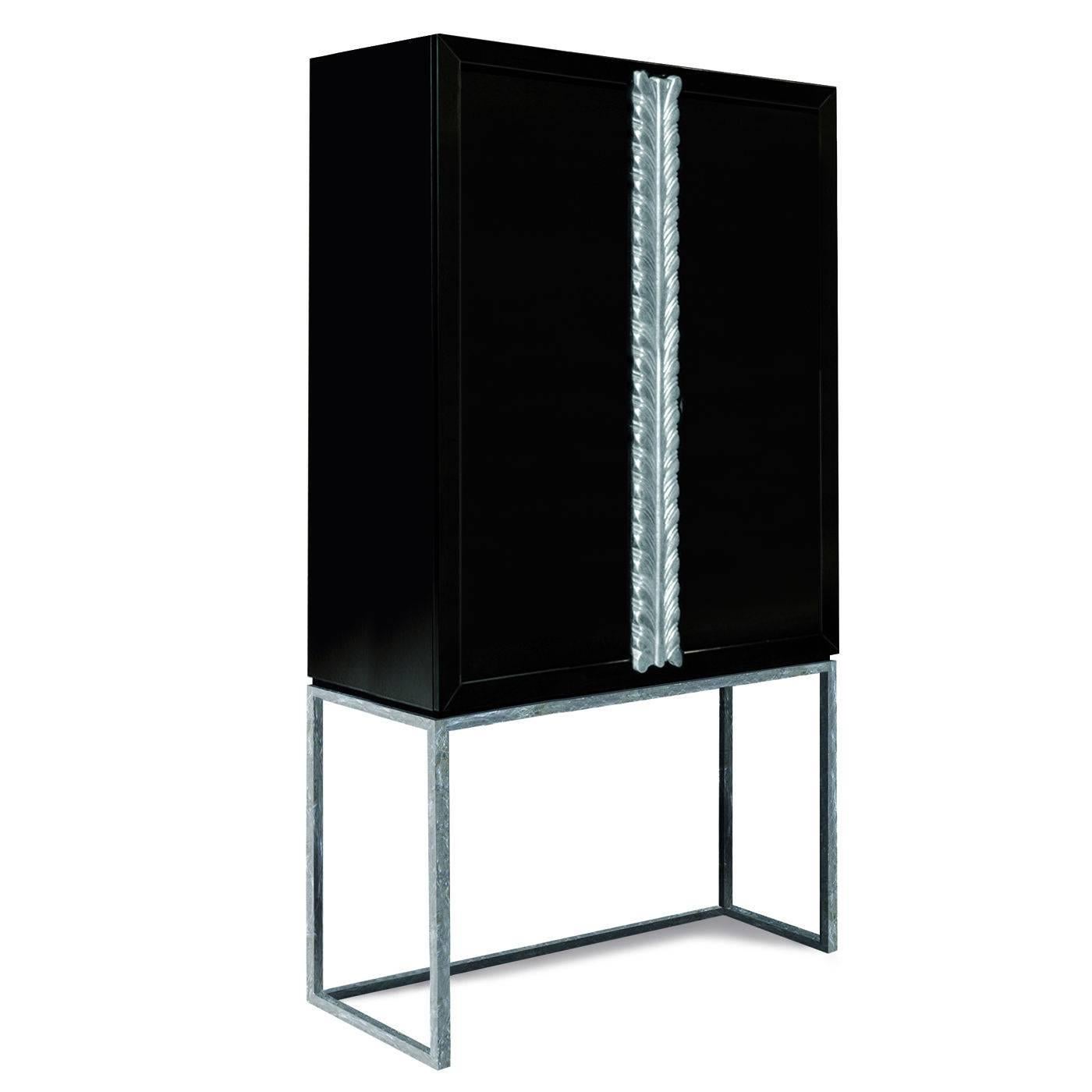 This elegant cabinet, ideal to store drinks and glasses, is crafted by expert artisans and features a metal frame adorned with silver leaf and a wooden top with two doors whose panels are finished with a hard, glossy black lacquer. The handles bear