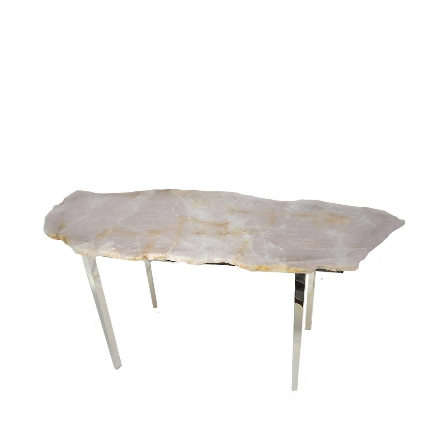 This coffee table features a large slab of handcut rose quartz from Madagascar. This breathtaking material features a variety of different inclusions throughout its natural surface, so that there will never be a dull moment as the eyes move all