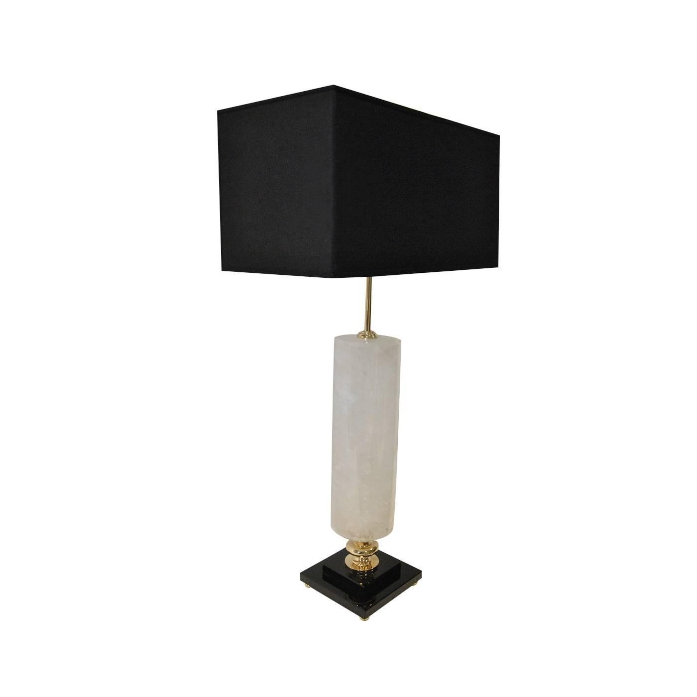 This table lamp features a refined rectangular and slightly transparent shade, which diffuses the light gently while also reflecting the light down on the natural irregularly cut clear quartz body of the lamp. The sophisticated color combination of