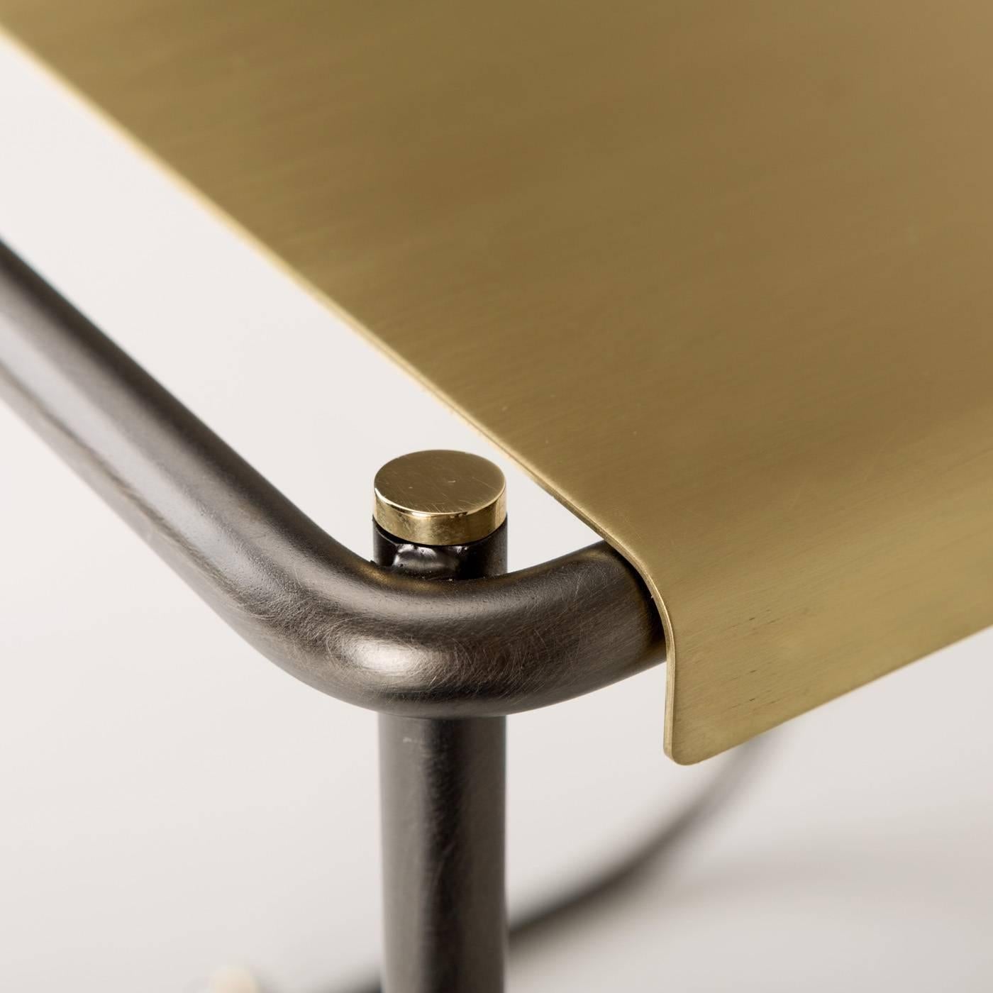 Ilario Innocenti and Giorgio Laboratore designed this contemporary stool made of two bent metal tubes running parallel around the seat and underneath it to support it. The iron structure is complemented with brass screws at the end of the tubes that