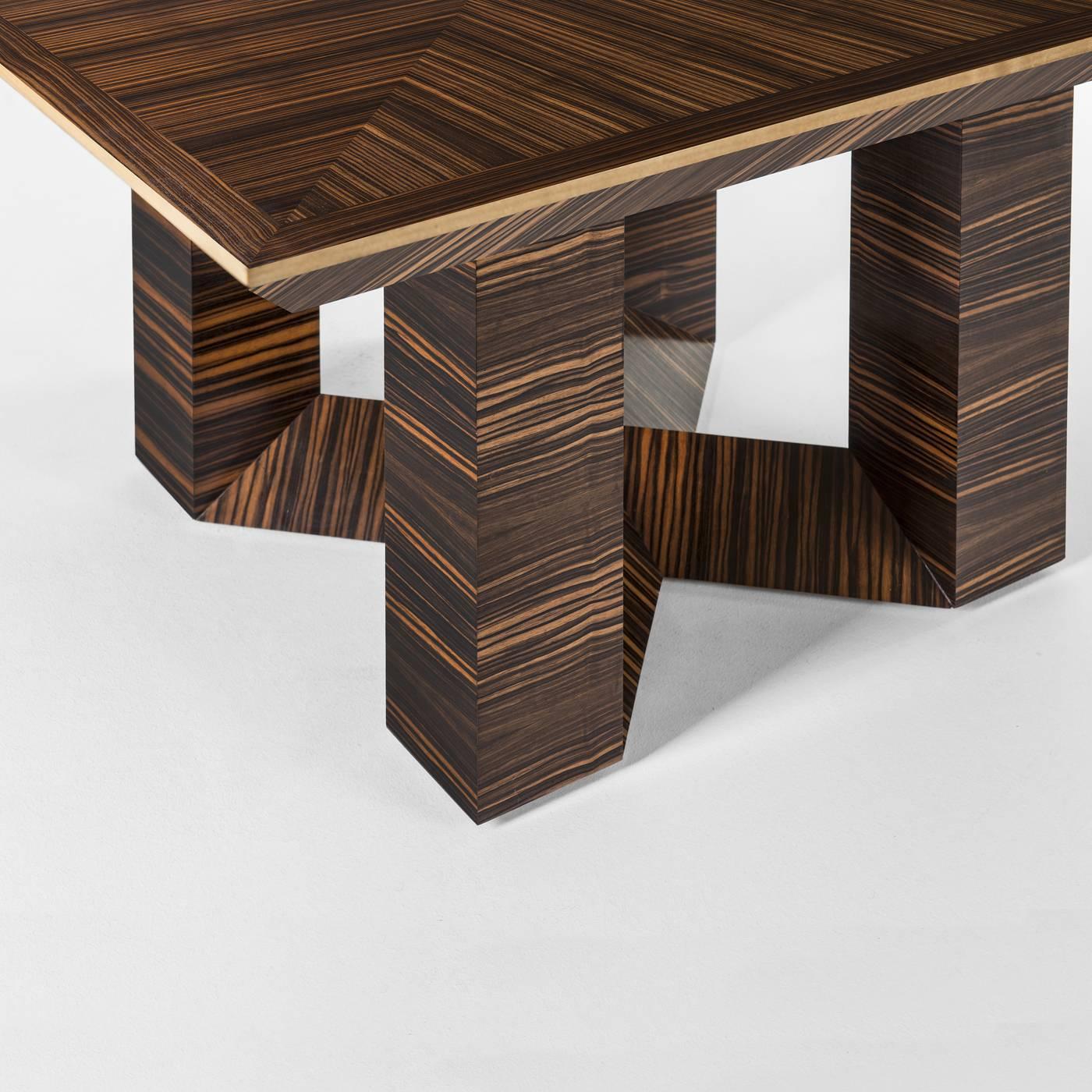 This table is in a unique octagon-shaped top which sits on top of a solid ebony macassar wood structure. The top features a pattern in the same wood, with the wood grain crossing, creating striking geometric shapes. The boarder of the table is in