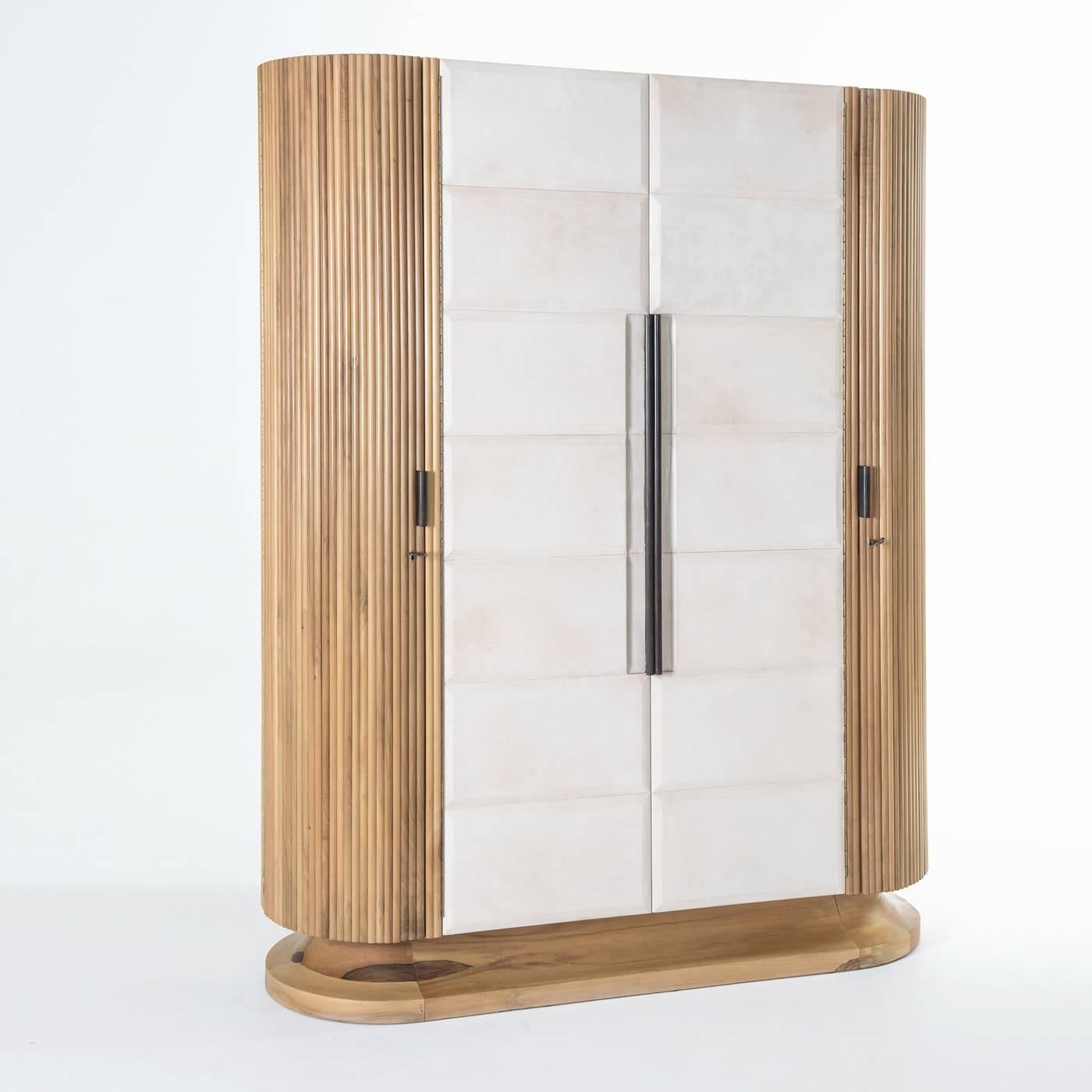 This wardrobe will provide luxurious storage for precious items. Its base is in walnut wood and its external structure is crafted in sections featuring walnut veneered sections on its two sides, and parchment covering on the frontal doors. The