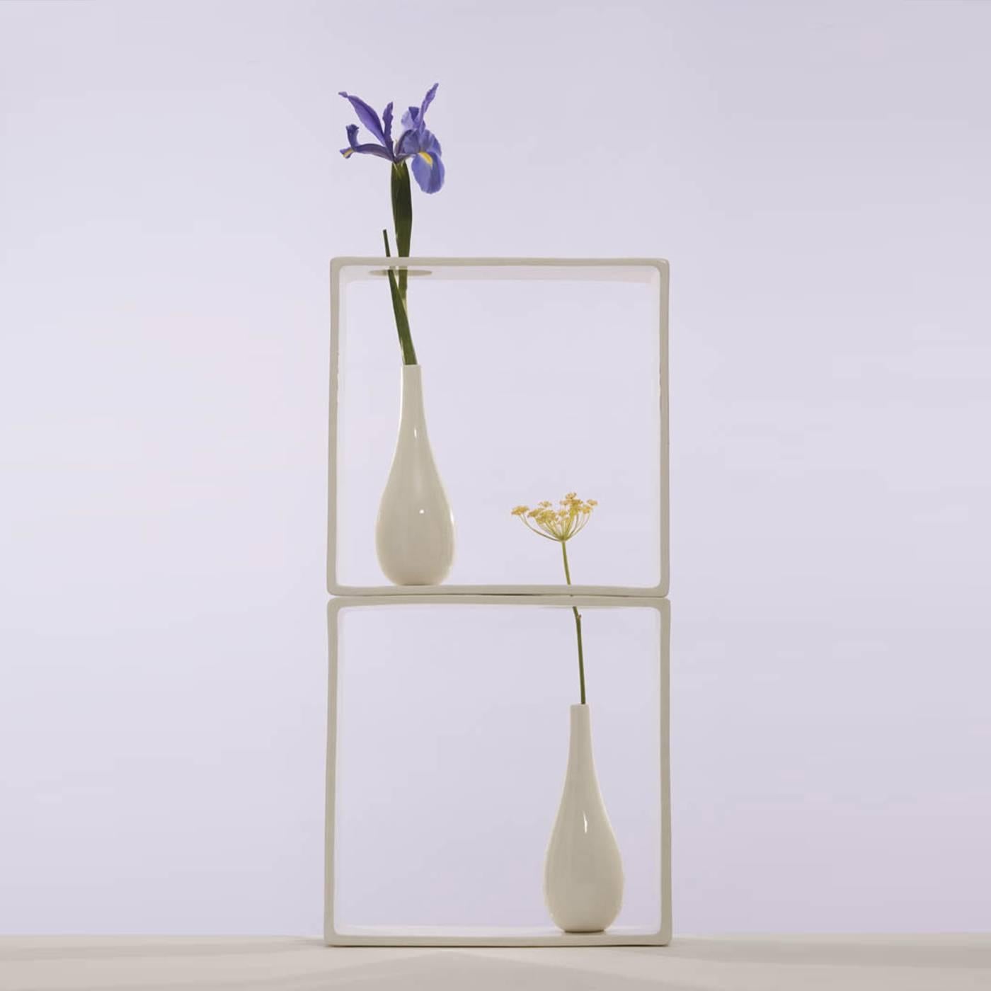 This striking vase is part of a collection of 18 designs by Andrea Branzi that created a garden of micro-environments enclosed in square elements all made in white ceramic. This one is particularly unique, since it features a hole at the bottom and