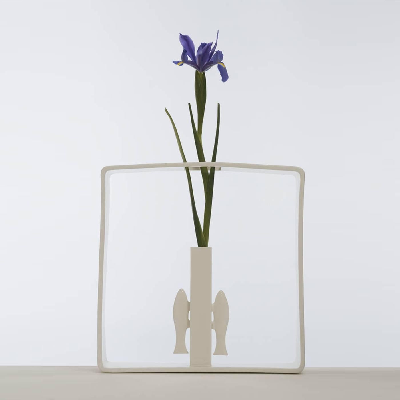 This delicate vase was created by Andrea Branzi as part of an 18-piece collection called Portali, featuring vases made in white ceramic enclosed in a square frame. In this case, the simple cylindrical shape of the vase is flanked by two vertical