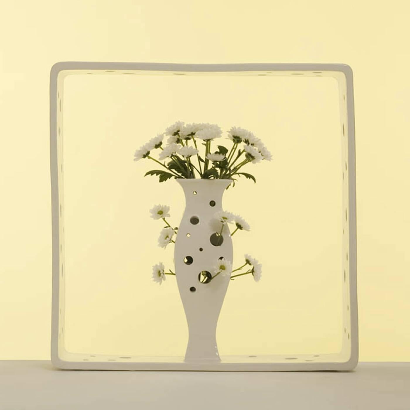 Modern and sophisticated, this vase was designed by Andrea Branzi as part of the Portali collection, featuring white ceramic micro-architectures enclosed in square frames. In this case the square encapsulates a pierced vase whose many irregular