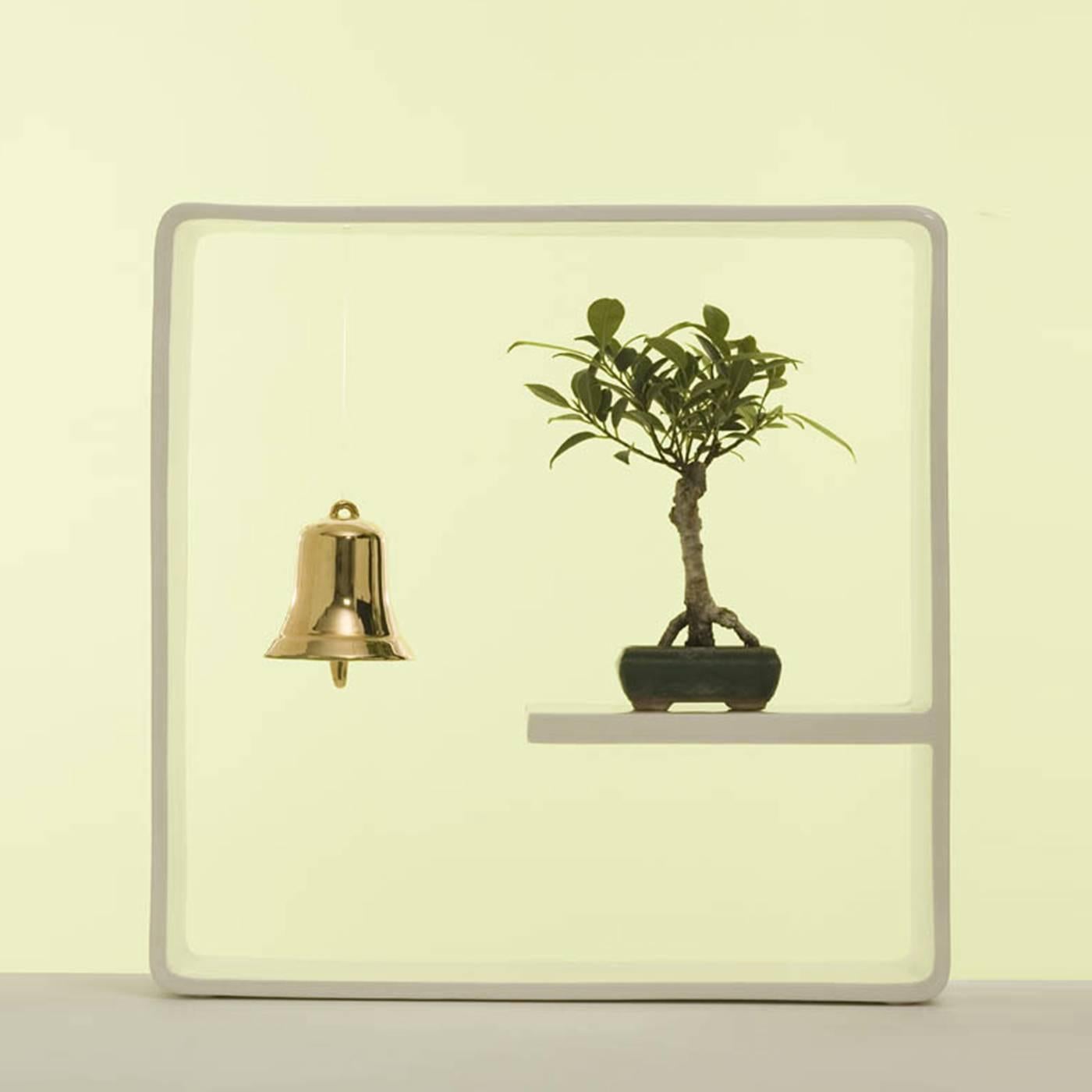This elegant and playful vase is part of the Portali collection, of 18 designs by Andrea Branzi in which a white ceramic frame encapsulates a micro-garden consisting of one or more elements to display flower arrangements. In this case, a single