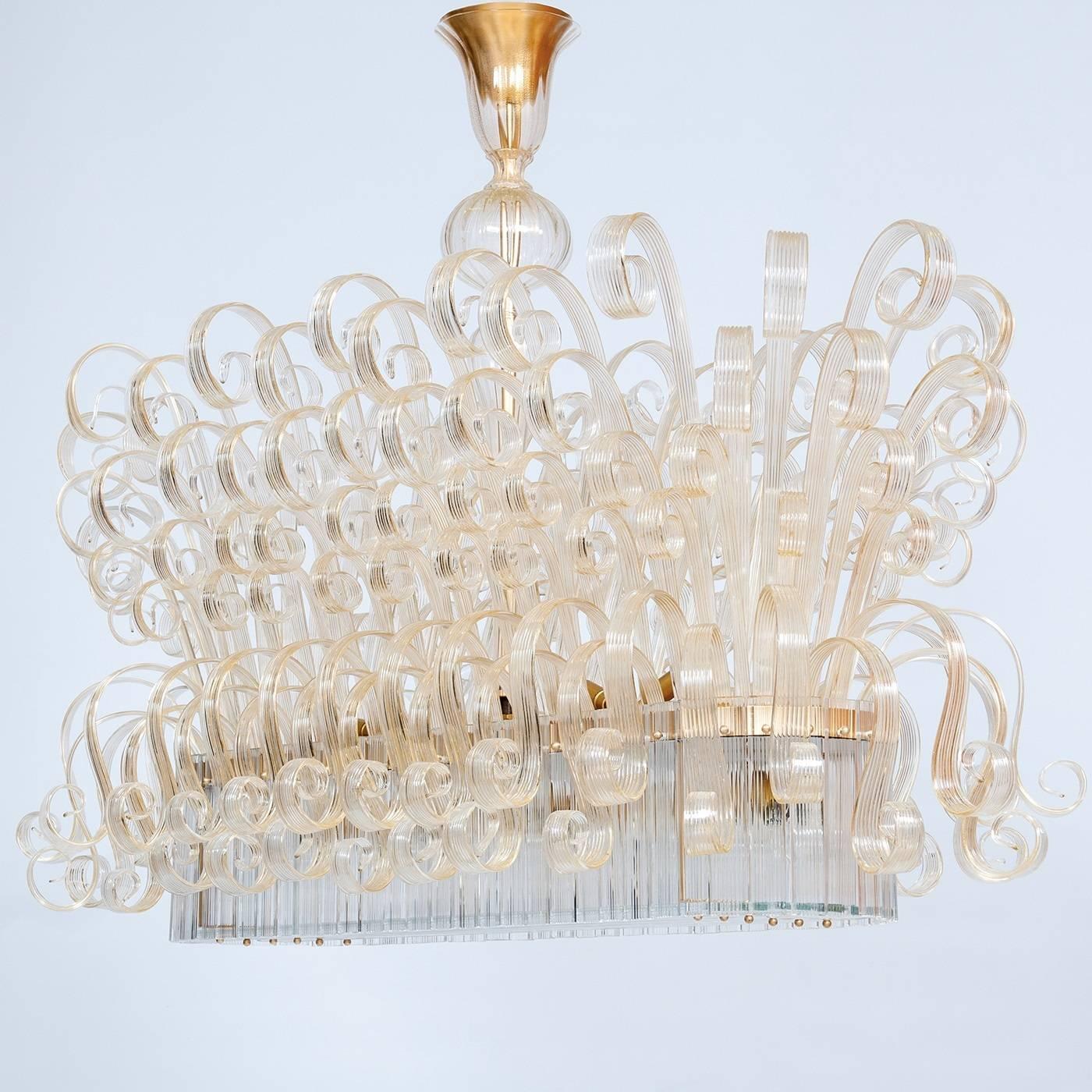 This incredible Venetian chandelier will bring a touch of luxury into any home in which it is placed. This limited edition piece features a 24-karat gold stem on top in its center which sits above by six tiers of ultra-thin hand-curled elements in