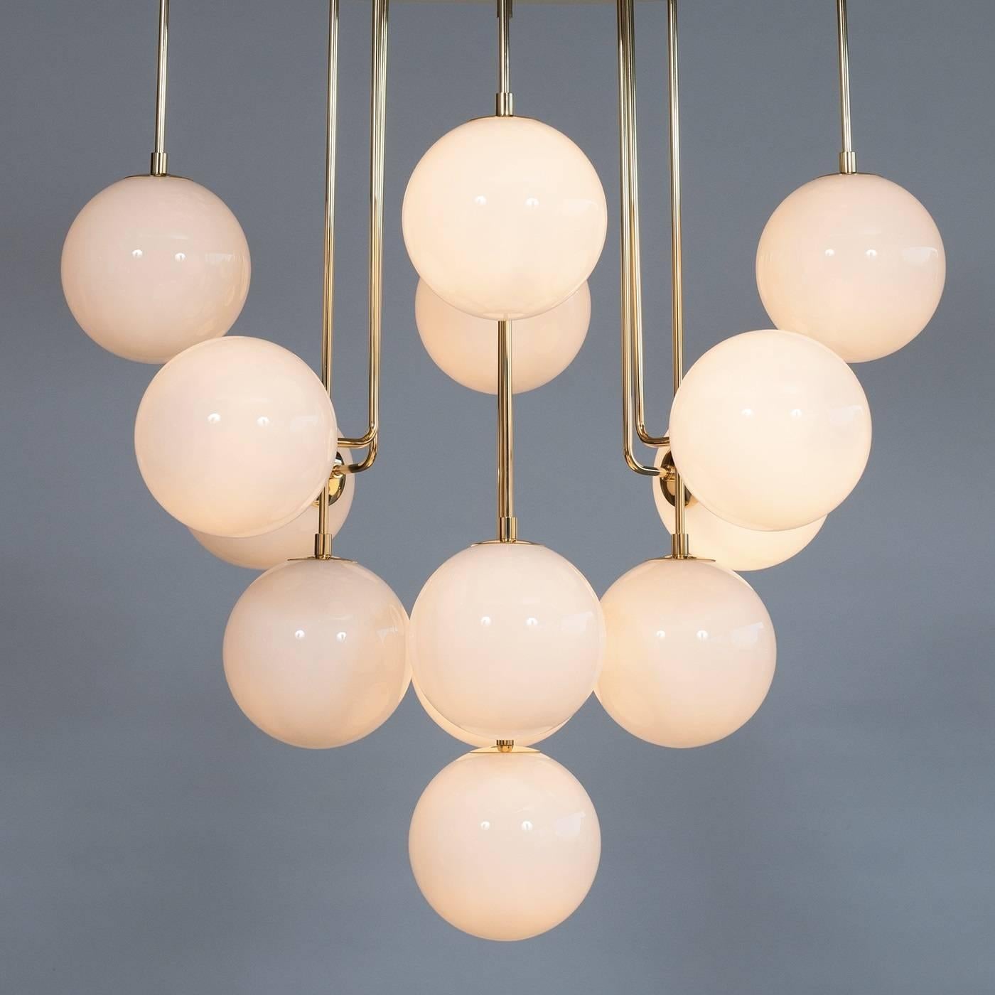 Italian chandelier in Murano glass, composed of white Murano glass spheres, willing in a different levels, with inside a light, supported by an elegant brass frame. The chandelier have thirteen lights. The chandelier is product by Giovanni Dalla