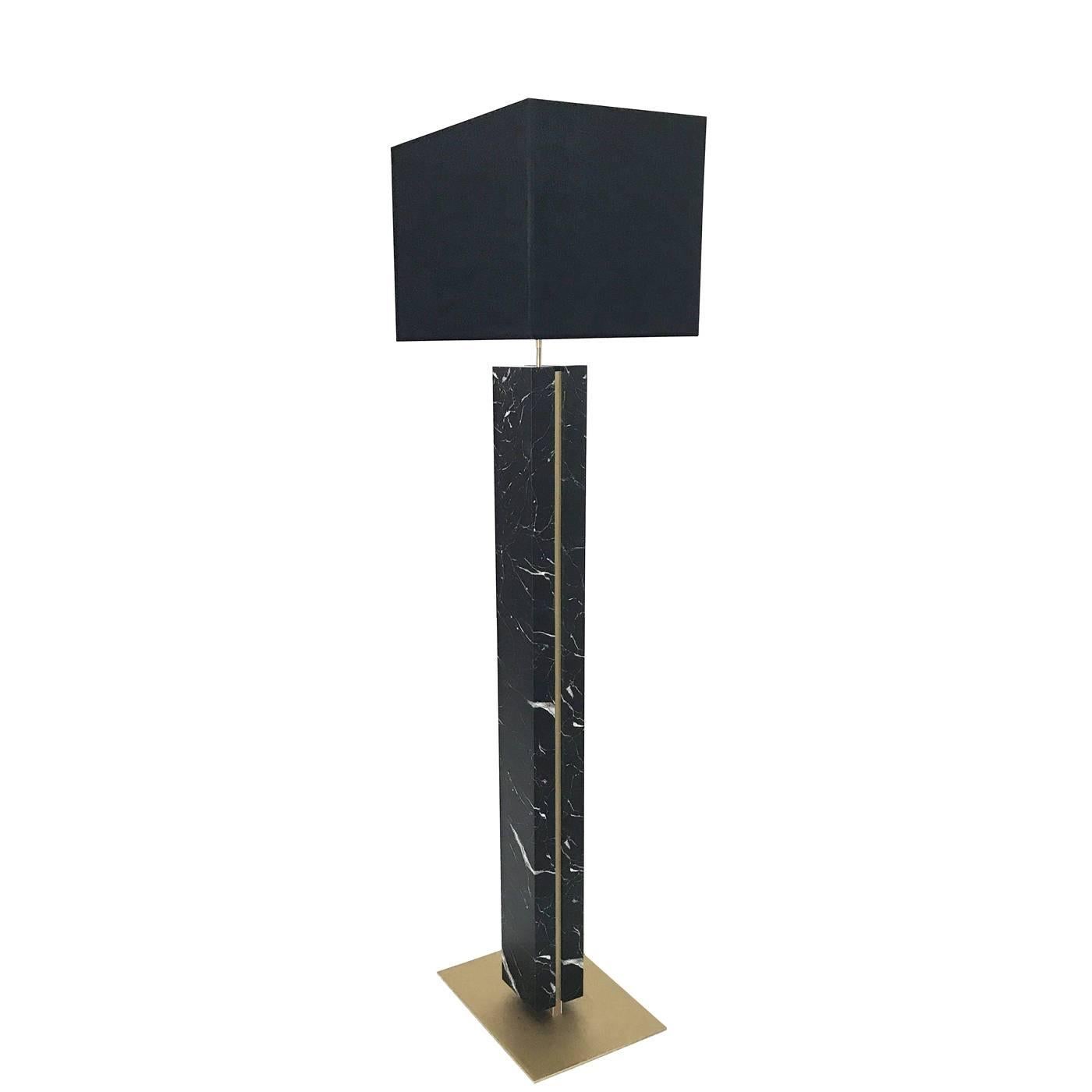 This superb floor lamp was made by hand by expert artisans using black Saint Laurent marble, whose luxurious Fine surface is covered in thin white and golden veins. The structure in brass complements the stone and comprises a square base and an