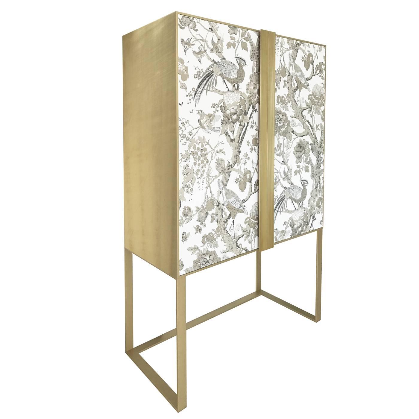 This exquisite cabinet will instantly enrich a dining room, thanks to its timeless allure and precious materials. It is ideal to contain beverages, glasses, and table linen and its structure is made in brushed brass with a golden finish that appears