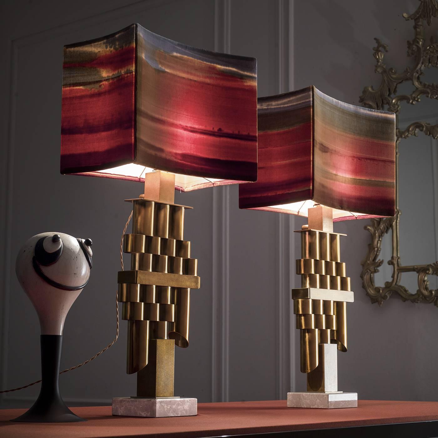 This lamp will be a striking accent when placed on a desk in the home or in an office. It can also be paired with a twin to create a double piece on either end of a large table. Its central structure, crafted using multiple tubular elements