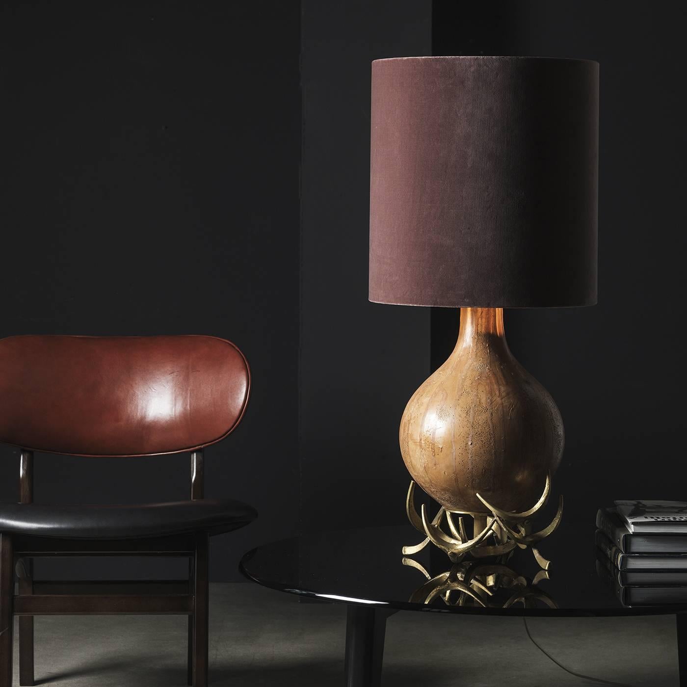 This table lamp will be perfect in either a contemporary or Classic decor and it features a sinuous body in terracotta with a Classic vessel shape that bulges at the bottom and tapers towards the top. The base is a composition of natural bronze