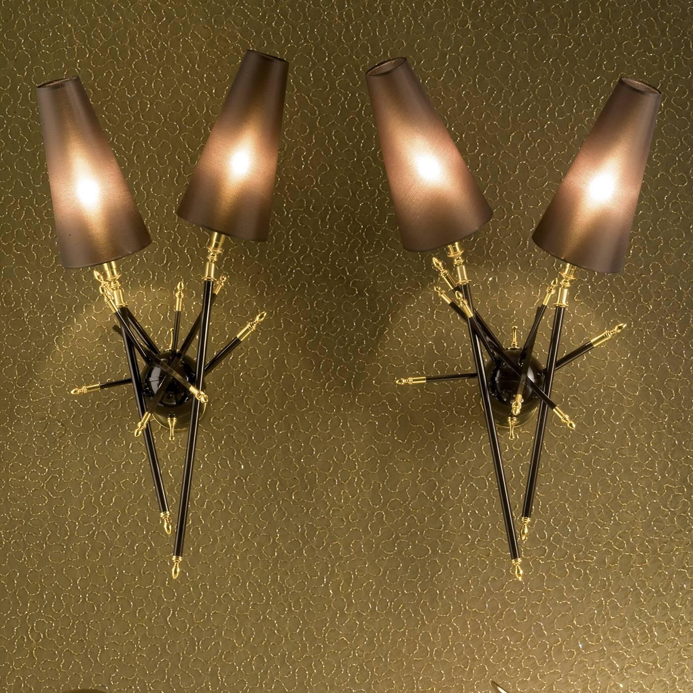 This sconce is a contemporary work of art whose unconventional structure gives it a unique sophistication. A central semi-sphere is anchored into the wall and from it extend a series of rods, two of which hold the light source, while the rest are