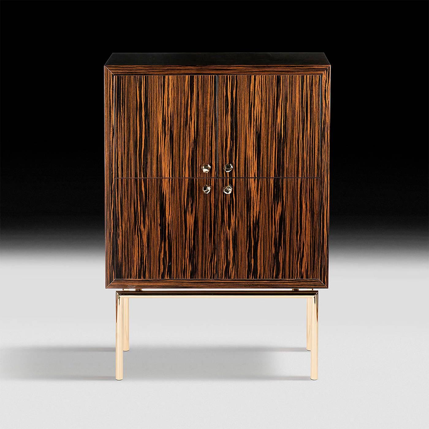 This exquisite piece is part of the Original Sin collection designed by Giorgio Ragazzini. The luxurious feel of this cabinet, with its ebony wood with a glossy finish and the metal structure with a precious coat of 24-karat gold, matches the other