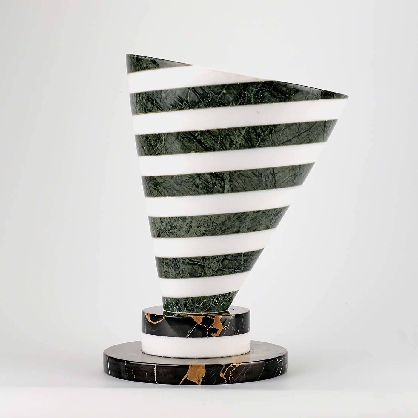 This centrepiece has an extroverted and contemporary silhouette. Two different marbles, white Carrara and green marble, compose the conical shape of the main element, creating an intriguing spiral design. The base is made of a large disc of black