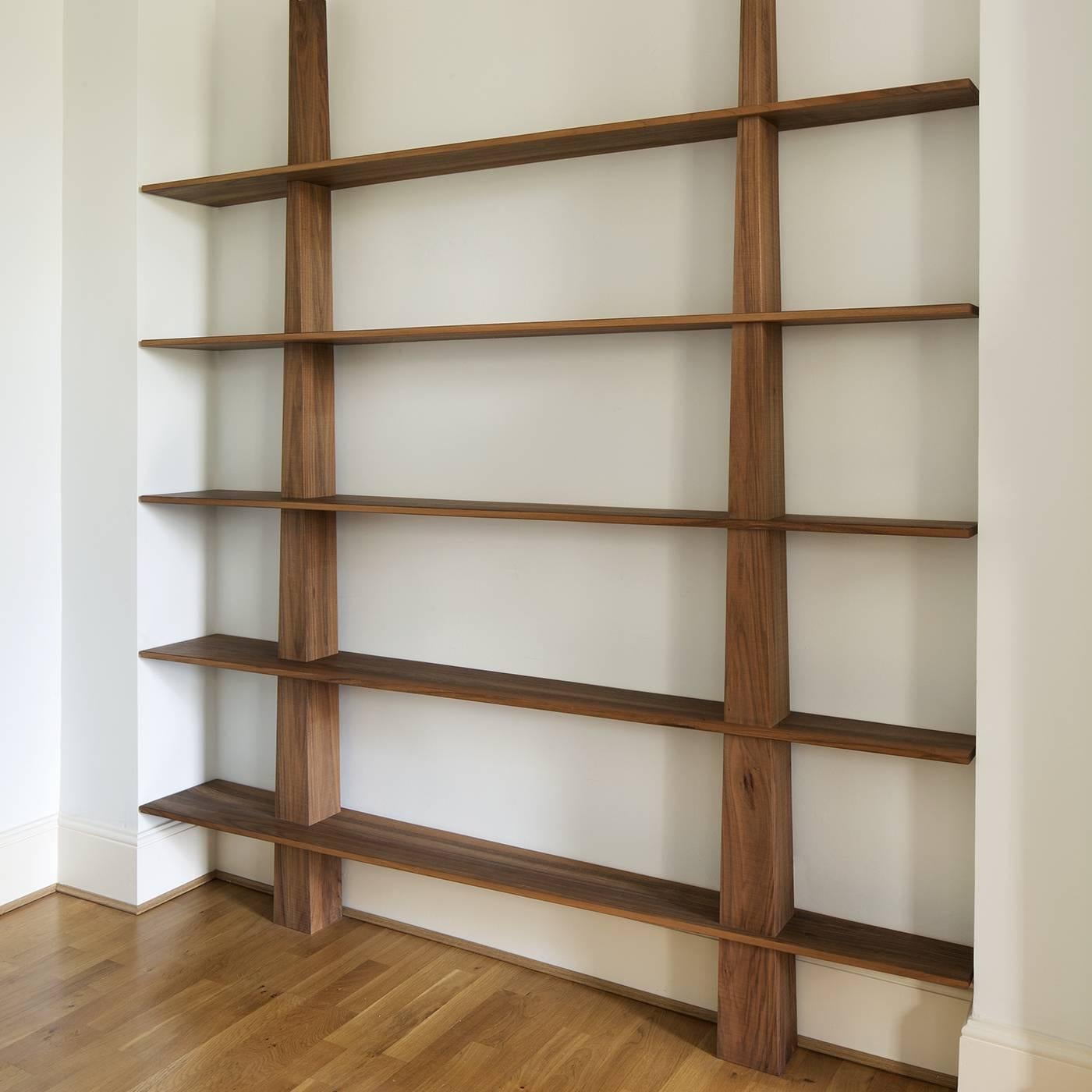 Stunning in its simplicity, this bookcase is an elegant arrangement of intersecting wooden planes. Designed by Mauro Dell'Orco, the bookcase is composed of two vertical elements that support five rows of trapezoidal shelves. The two vertical planes