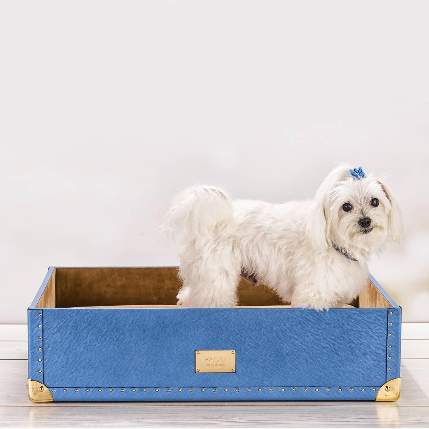 This sophisticated bed for a cat or a dog elevates a simple everyday object to luxurious statement piece and is inspired by the old-fashioned design of traditional traveling trunks. The external cover is in pale blue Saffiano leather with an