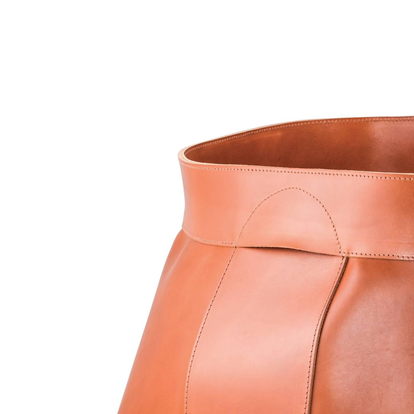 Part of the Woody series, this storage basket is crafted using artisanal methods and the finest leather, which was dyed using vegetable pigments to create a soft and durable texture. The result is a deep orange glow that enriches the unique