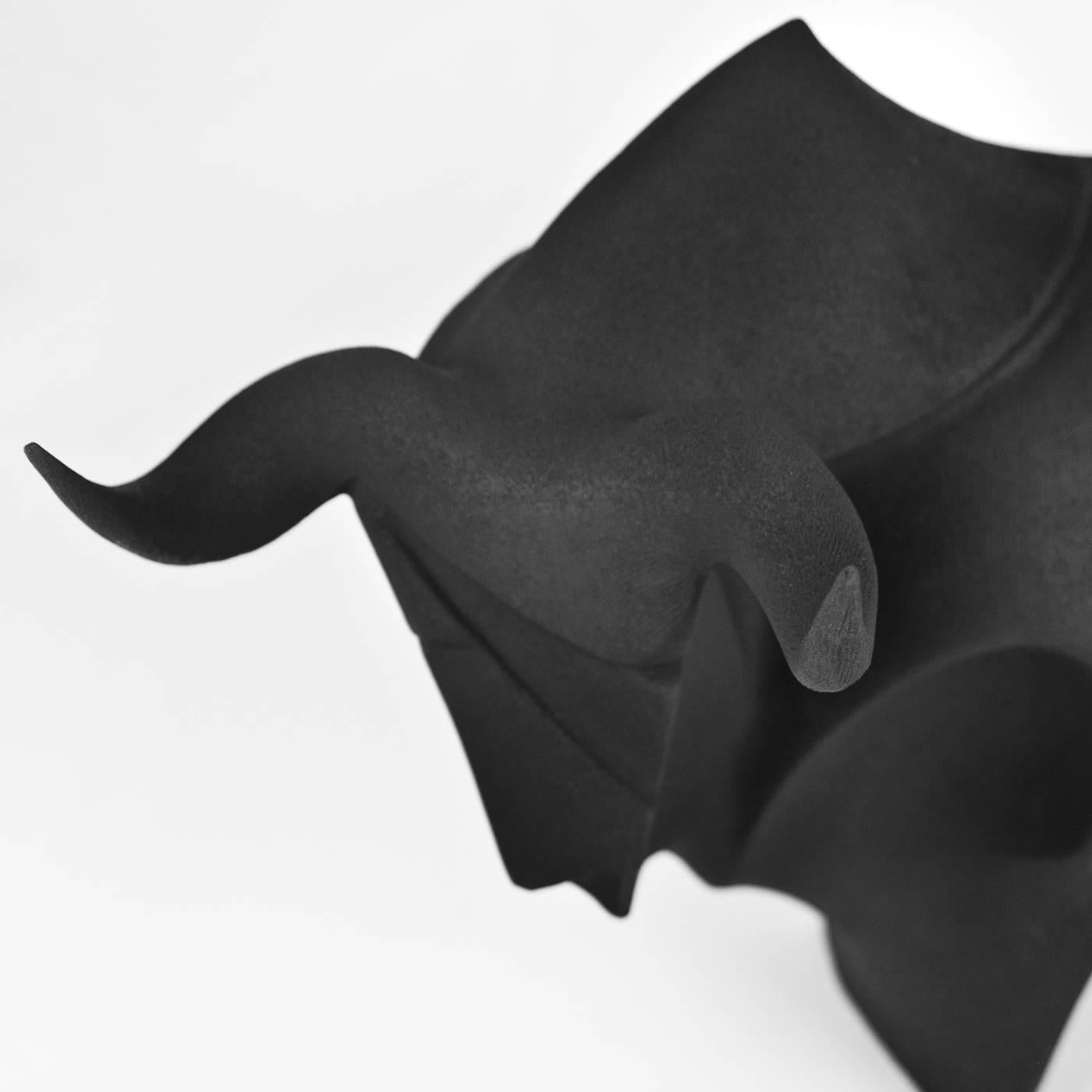Completely handmade of ceramic, the matte black finish of this remarkable piece adds dramatic force to the sinuous geometric shape of the bull, regarded in ancient times as a symbol of prosperity. The strength and regal poise of this eye-catching