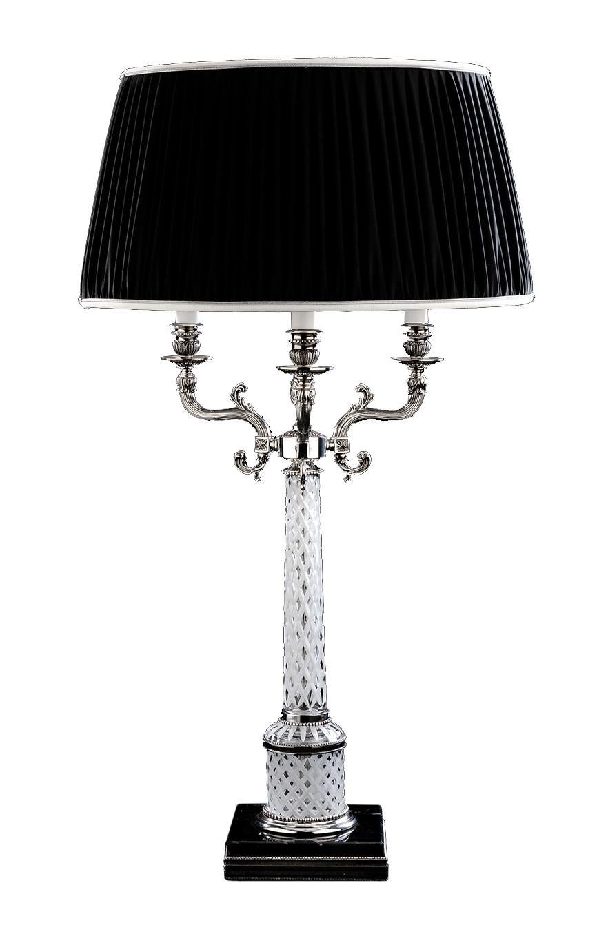 This elegant lamp features a black square marble base, with silver accent along its border, supporting a slim handcut crystal body with three scroll-shaped arms. The bold drum shade in pleated black fabric is a perfect contrast to the luxuriously