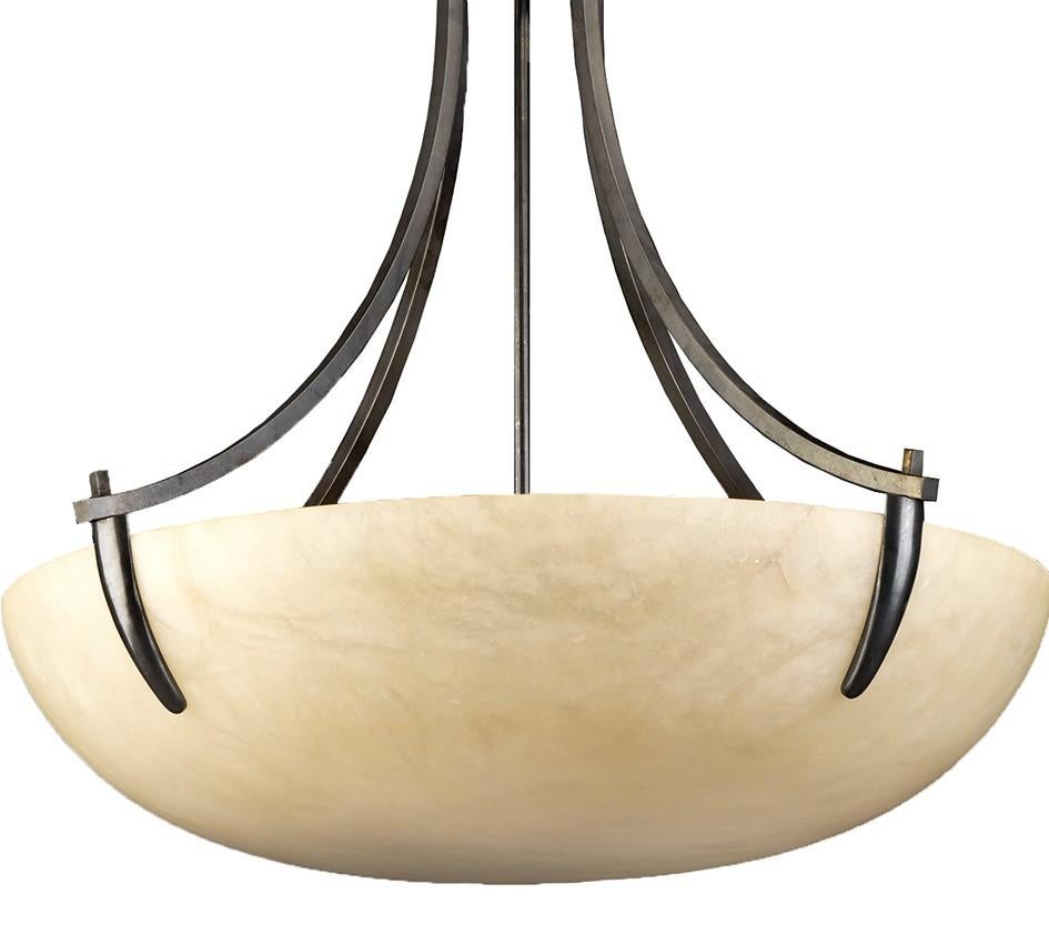 This exquisite chandelier embodies Badari's philosophy of fusing tradition and functionality while focusing on the quality of their materials. Striking in its simplicity, a stately bowl light fixture fashioned of ivory alabaster is suspended by four