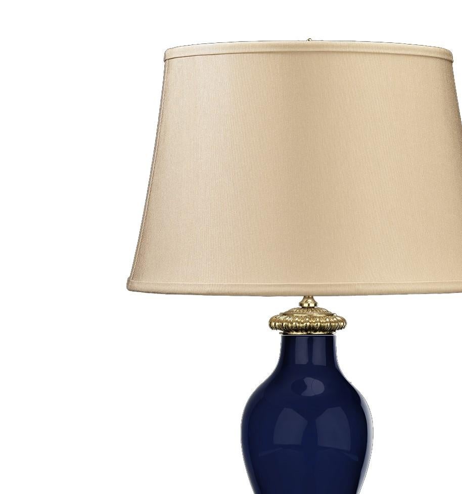 Stunning in its simplicity, this elegant porcelain lamp will add a touch of refinement to any living room or study decor. The lamp base, crafted in a timeless ancient Roman amphorae shape, is glazed in a striking cobalt blue color. The rich vase