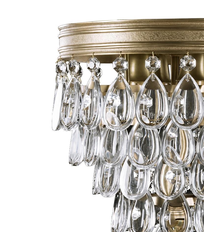 A captivating showcase of traditional craftsmanship, this chandelier will infuse intrigue and timeless allure into an entryway or living room. The piece features a tiered design with gradient rows of shimmering crystals cascading downwards to a