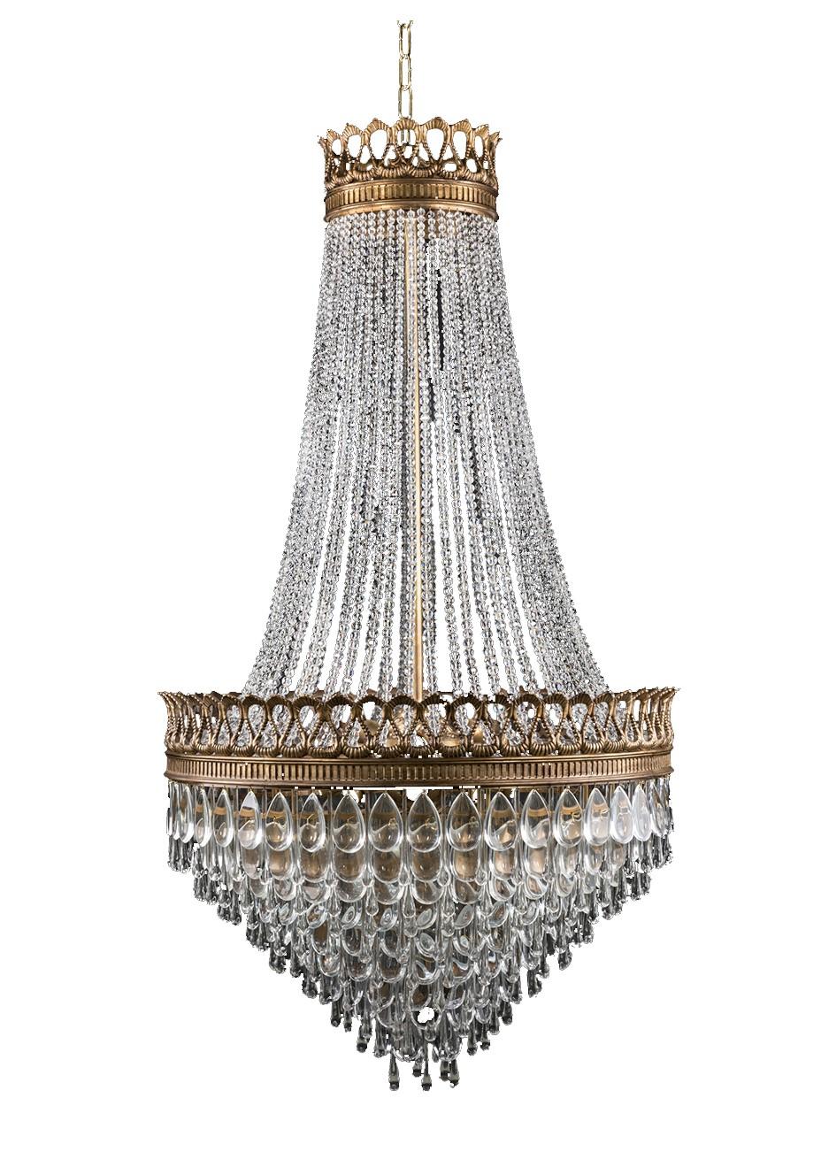 Shining with understated simplicity, this iconic chandelier is characterized by Classic sophistication and elegance. The sleek, balanced form is composed of strands of cascading crystals, elegantly curving to connect to an ornate brass ring lined