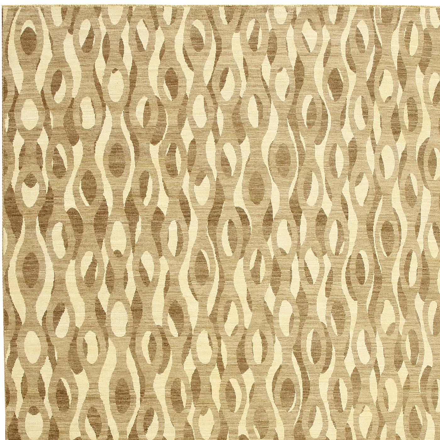 From afar, the pattern that adorns this exquisite handmade carpet is reminiscent of a leopard's skin. From close by, the decoration is made of connected rings of beige, brown, and light brown. The color palette is delicate and warm and will