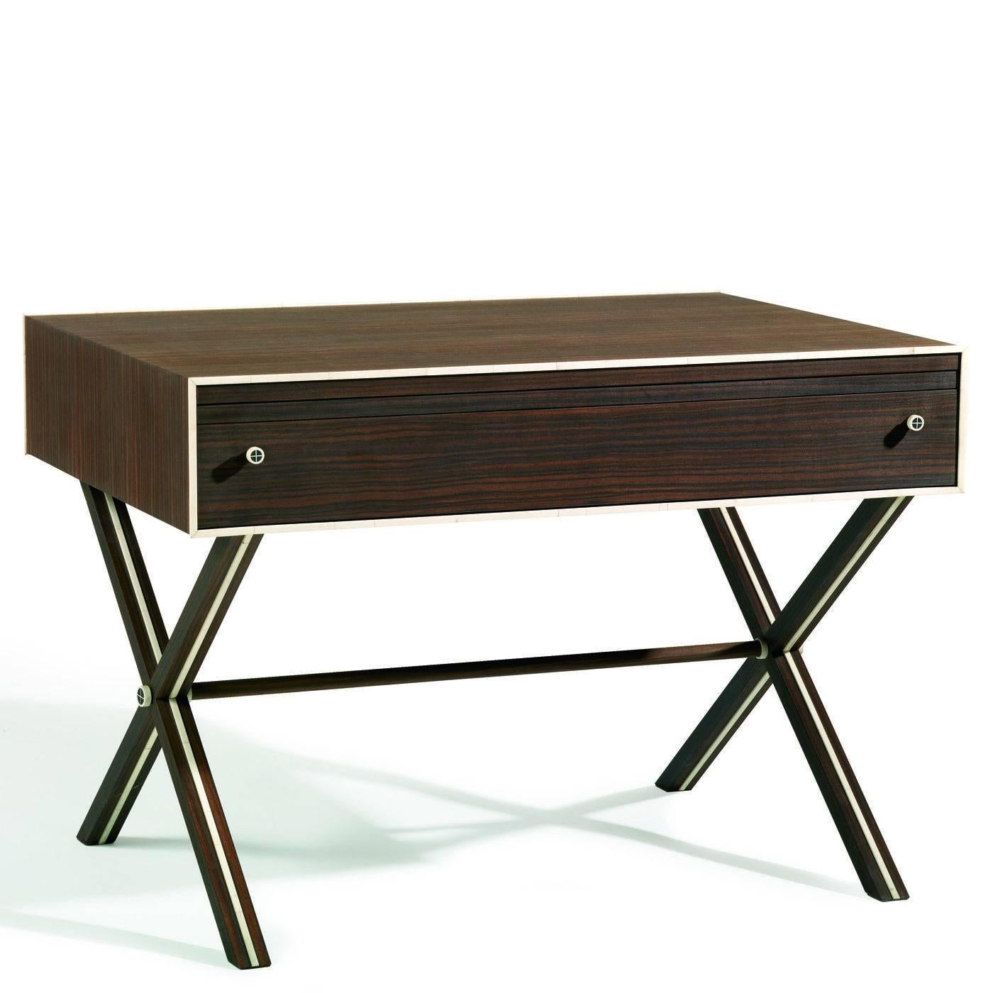 This elegant table is veneered in ebony Macassar wood. It features one drawer (with internal compartment) and an extractable surface. The exterior is embellished with horn details running around the edge of the front and inside the four crossing