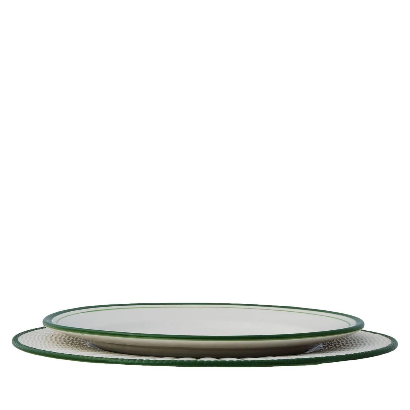 An elegant white background contrasts with the verdant topiary shrubs hand-painted on the ceramic set of eight plates. The wicker placeholder is white with a green border.