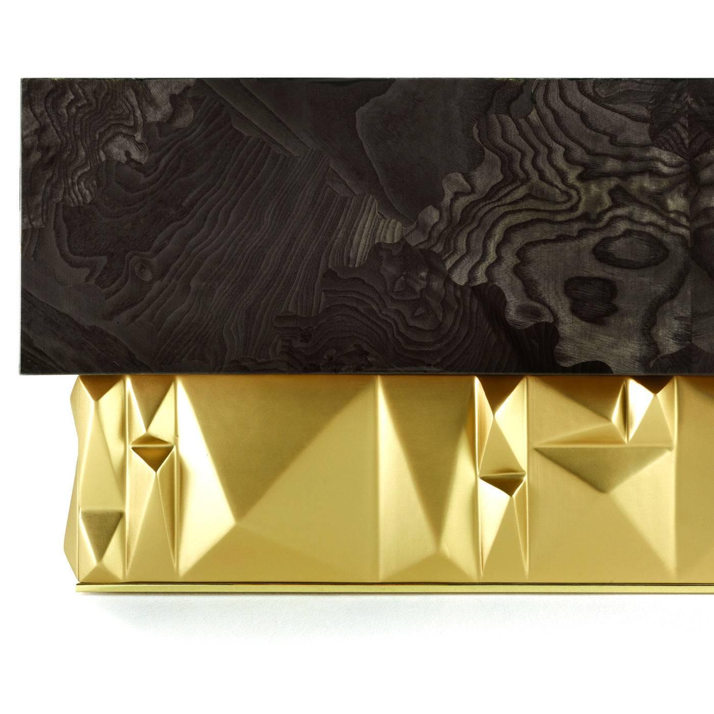 This striking coffee table is part of the Ulysse collection, designed by the creative duo Alex-Charles. The eccentric base, with its satin effect natural brass finish, features geometrical 3D decorations recalling the ashlar blocks and creating a