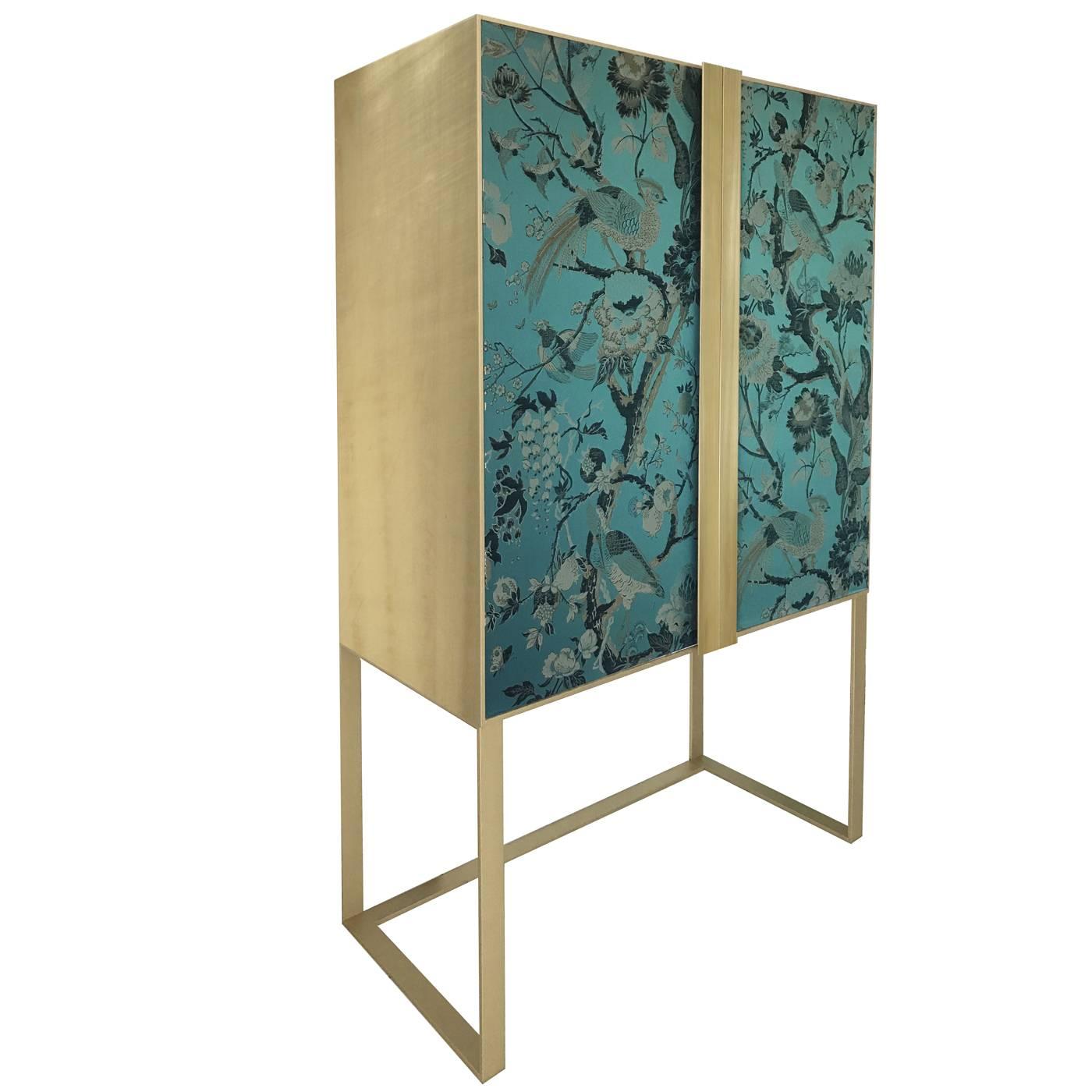 This sophisticated cabinet will complement any decor, thanks to its Minimalist Silhouette and the noble materials used. Its timeless allure is given by the brushed brass structure and handles that elegantly frame the cabinet doors in wood entirely