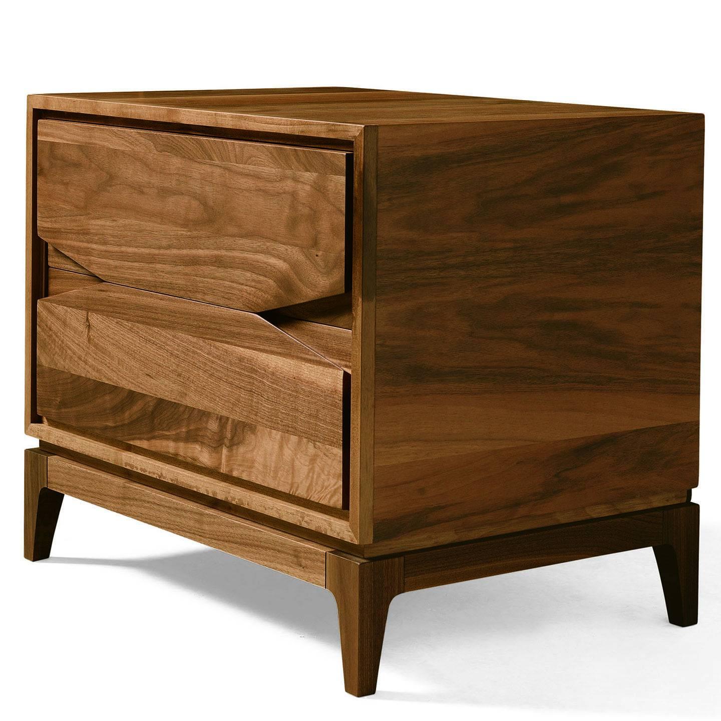 This striking nightstand can be paired with the San Paolo chest of drawers to decorate a bedroom with the remarkable natural patterns of the walnut veneer that covers its structure in slatted wood. The simple Silhouette of the piece features two