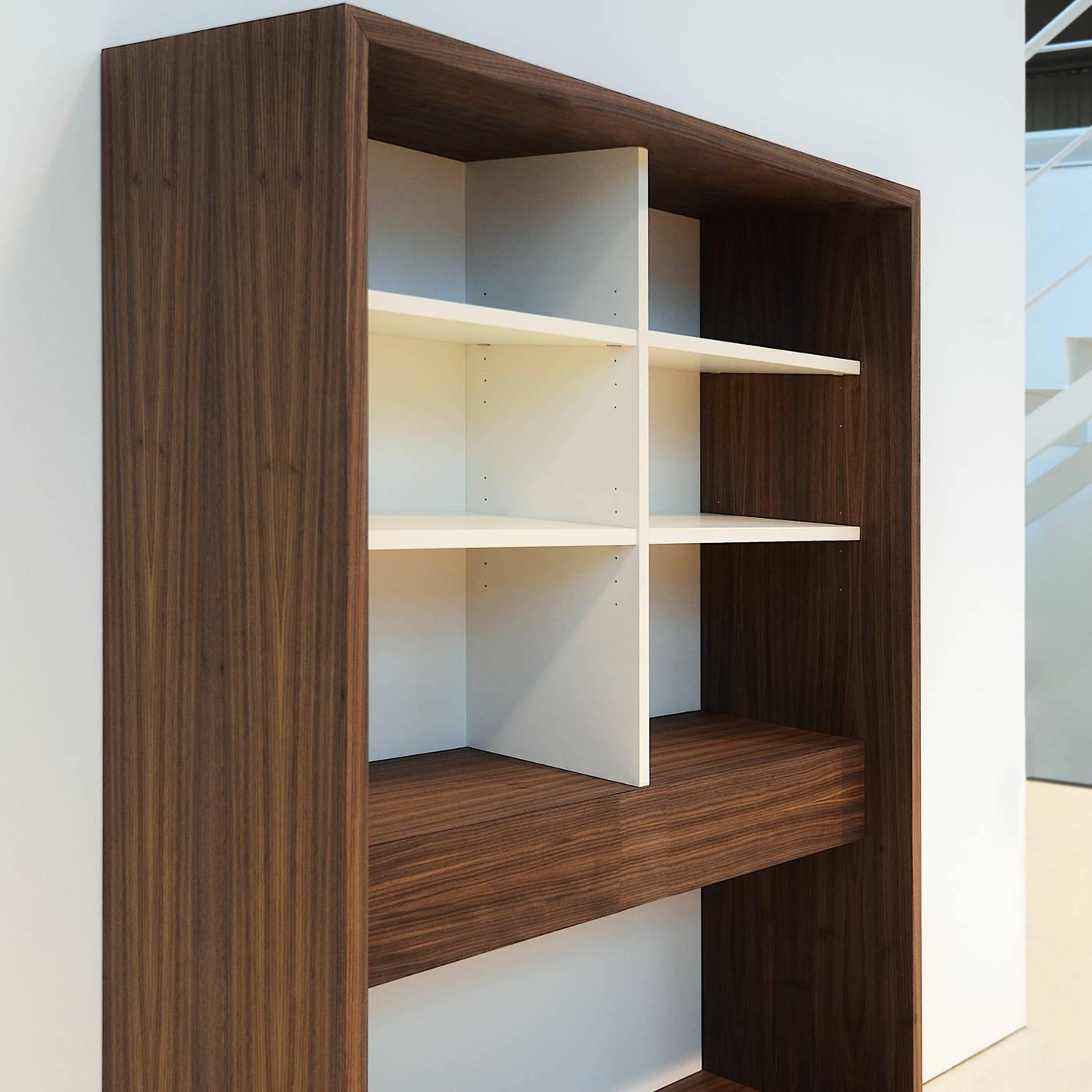 This remarkable bookcase blends natural materials, refined finishes, and impeccable details for a result that is elegant and versatile. Entirely handmade with canaletto walnut veneer, except for the back and the inner top shelves lacquered in white