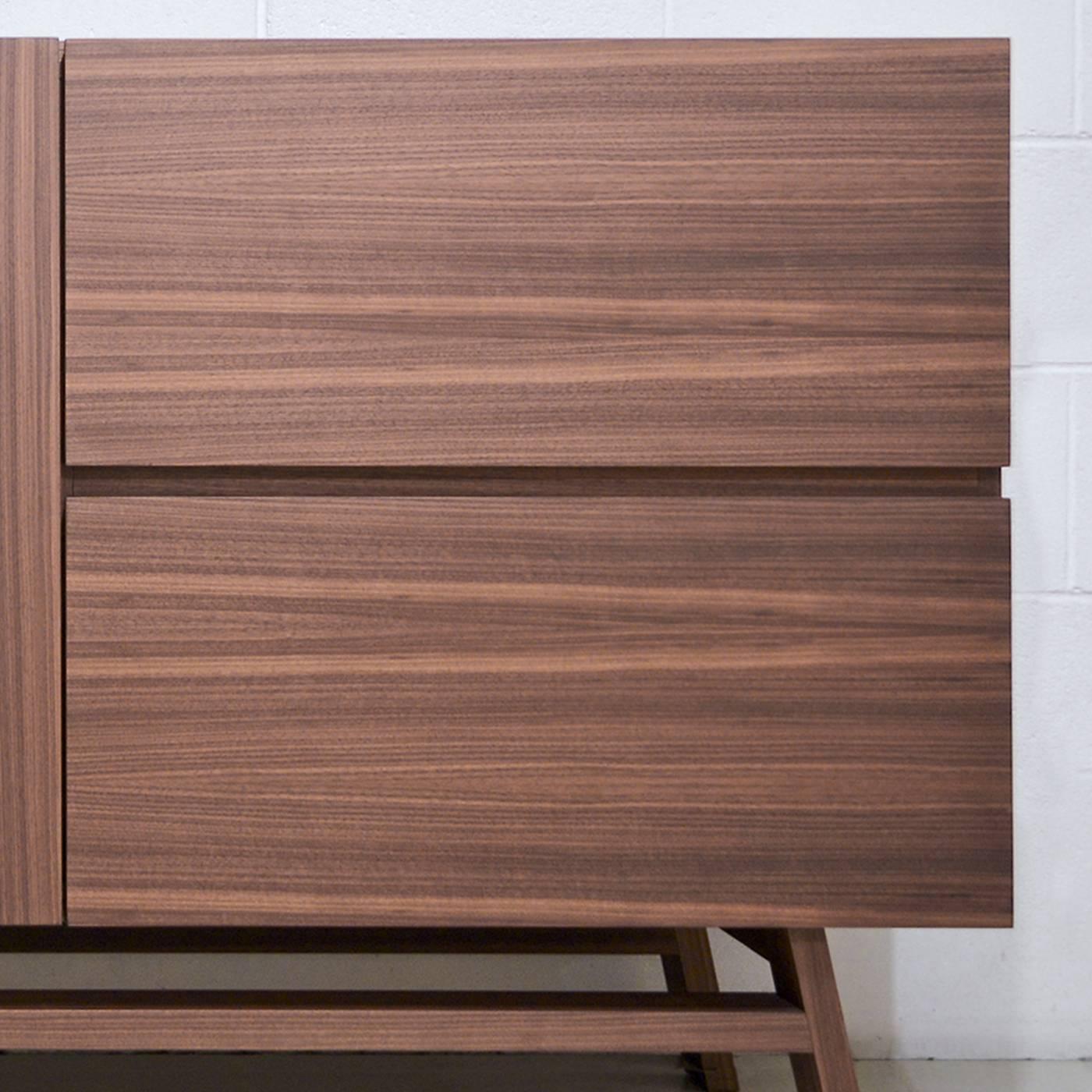 This minimalist sideboard in Canaletto walnut veneer, both inside and outside, displays high craftsmanship in all its details. This unique piece has two hinged doors revealing a single internal storage area with an adjustable shelf, two visible