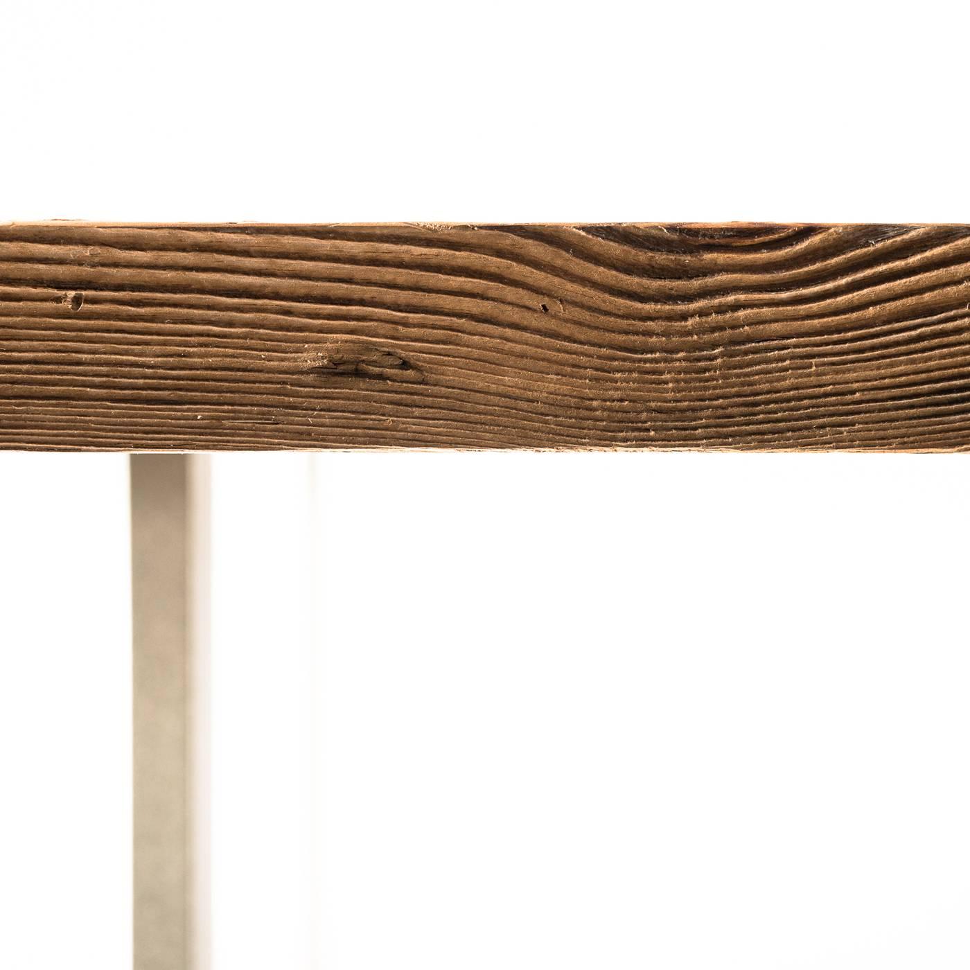 This stunning table is made of inlays of salvaged wood carefully selected and individually crafted by expert carpenters to create a unique piece where tradition and innovation blend. The rectangular top is supported by two austere handmade iron legs