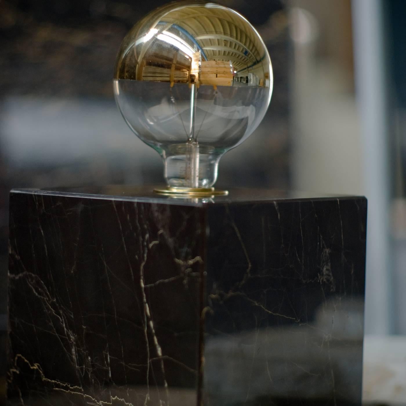This table lamp is inspired by the materials used during the Renaissance by the Medici family in Florence. The minimalist style of its geometric silhouette is combined with the Portoro marble to create a timeless object that can be used in an