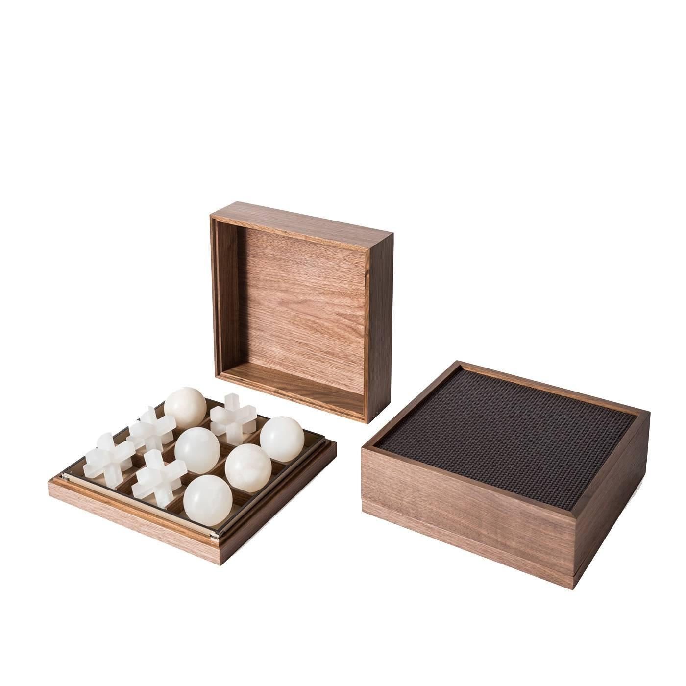 Traditional craftsmanship and noble materials make this game box the ultimate sophisticated accessory. A perfect gift and a precious addition to any home, this box is made of wood with the top of the lid upholstered in leather. The alabaster noughts