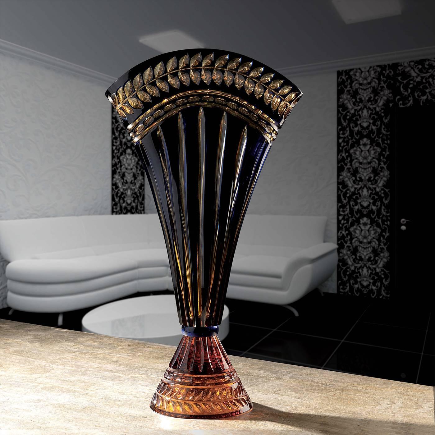Evoking Classical Roman designs, this handcrafted, blown crystal vase has a unique fan-shaped Silhouette highlighted by shades of amber and blue. An amber, conical base supports a majestic body of 'incamiciato' glass with vertical ridges that