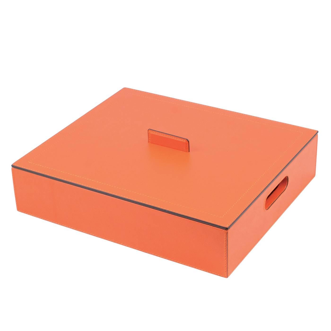 This striking case is an elegant addition to any playroom and will add a splash of color and sophisticated luxury to any home. The wood box is entirely covered in leather with a bright orange color. It features a handle for the box and one for the