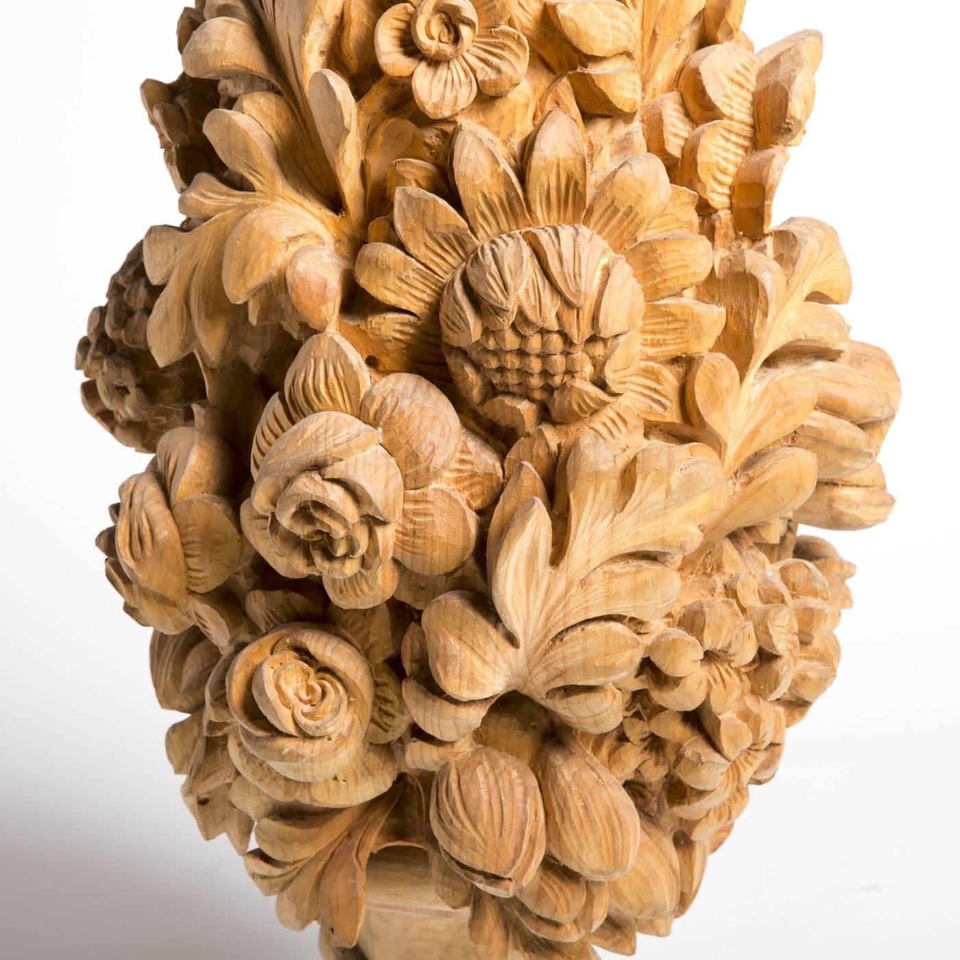 Decorative centerpiece by Bartolozzi e Maioli, masterfully hand-carved out of a block of Austrian pine with elegant flower and foliage adornment. The piece rests on a hexagonal pedestal with a natural wax finish.
