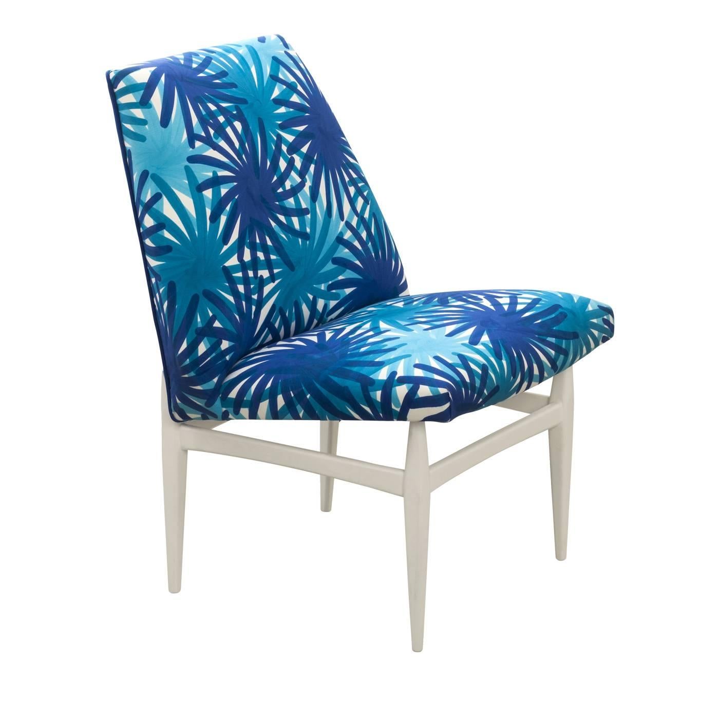 This elegant chair has a wood structure finished in white enamel. Its seat and back are covered in 100% cotton decorated using the pigment printing technique with a pattern of blue and turquoise fireworks.