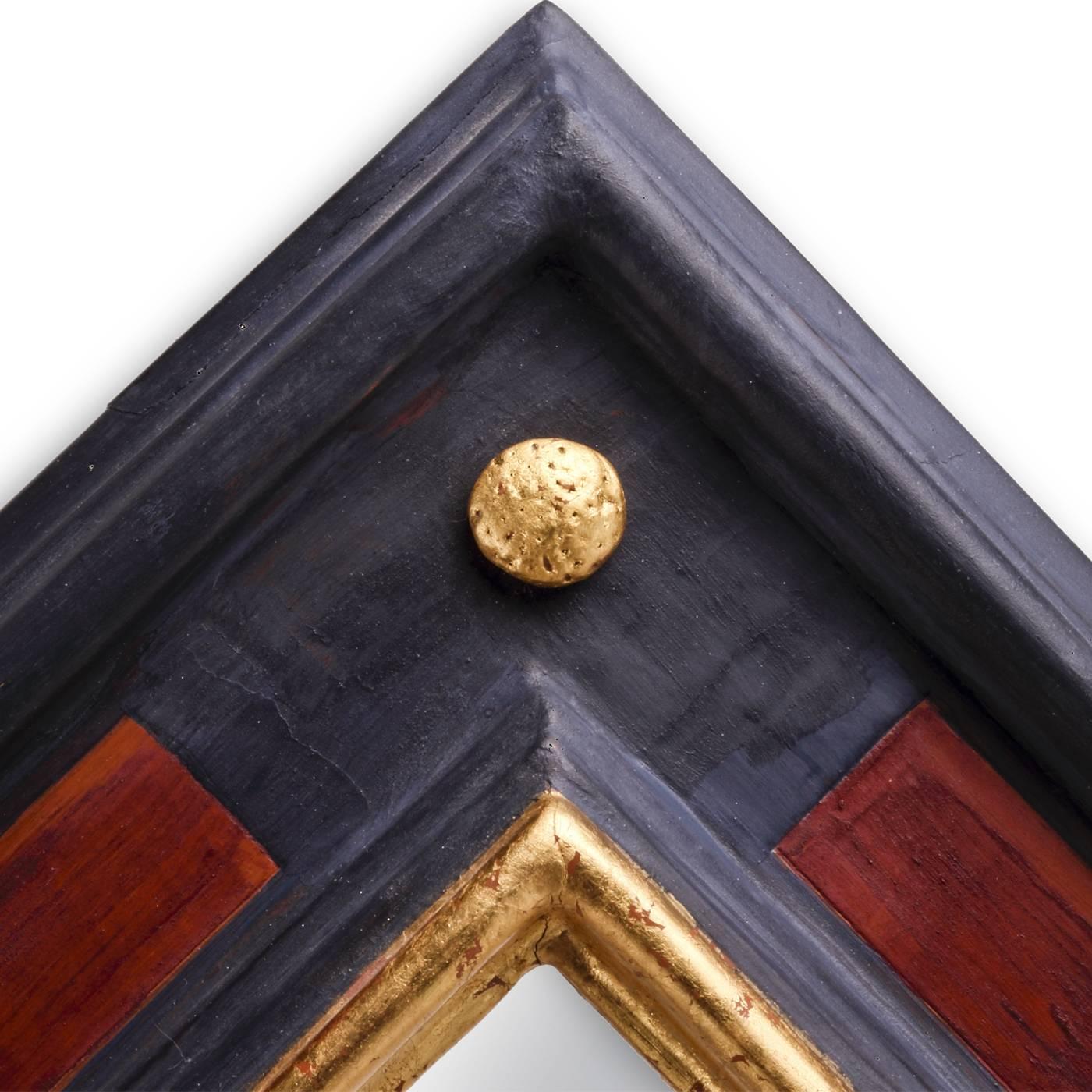 Modern and sophisticated, this mirror was made by hand using reclaimed wood and hand lacquered with a deep shade of blue highlighted with accents in dark red and adorned with buttons on its four corners. The buttons are finished with pure gold leaf