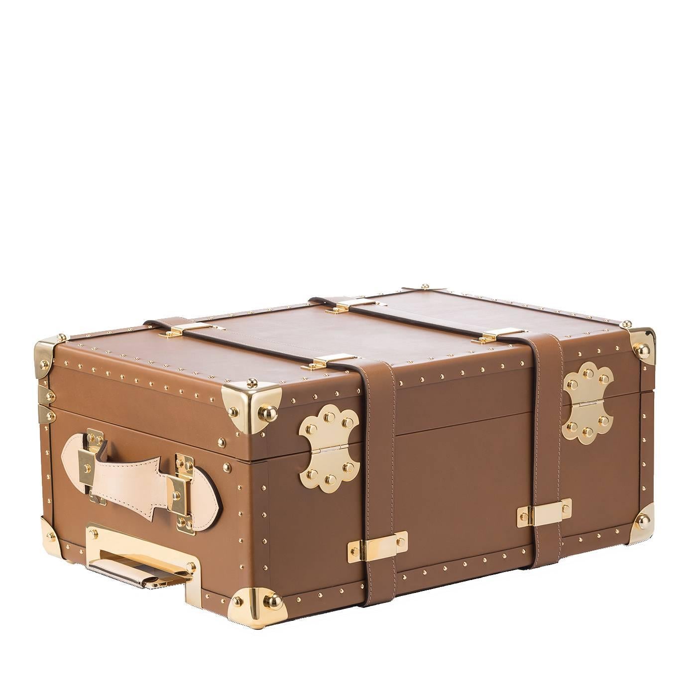 This elegant and light trolley is a refined piece of luggage with an old-fashioned appeal. The exterior is in cognac-colored leather with vacchetta leather handles. The extendable handle and the metal details are in aluminium with a gold finish. The