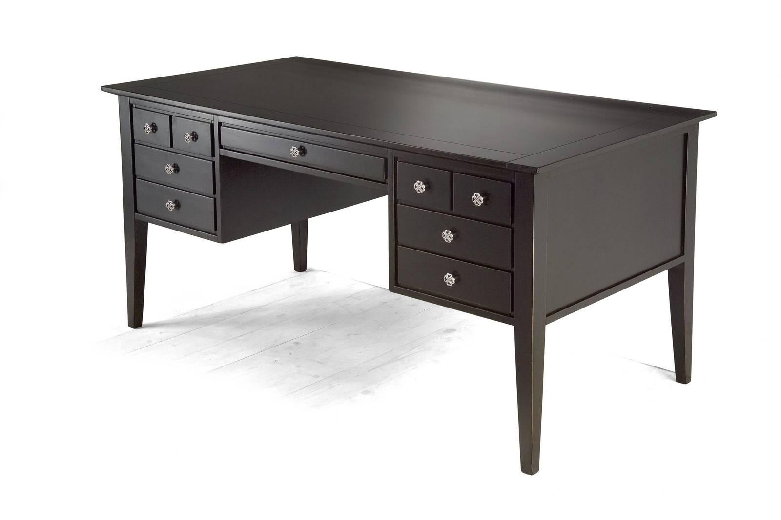 This elegant desk was crafted of solid wood and its timeless shape makes it a refined addition to both a traditional and a modern decor. Its dark finish can be customized, along with sizes, the material used to make the top, and the handles. In this