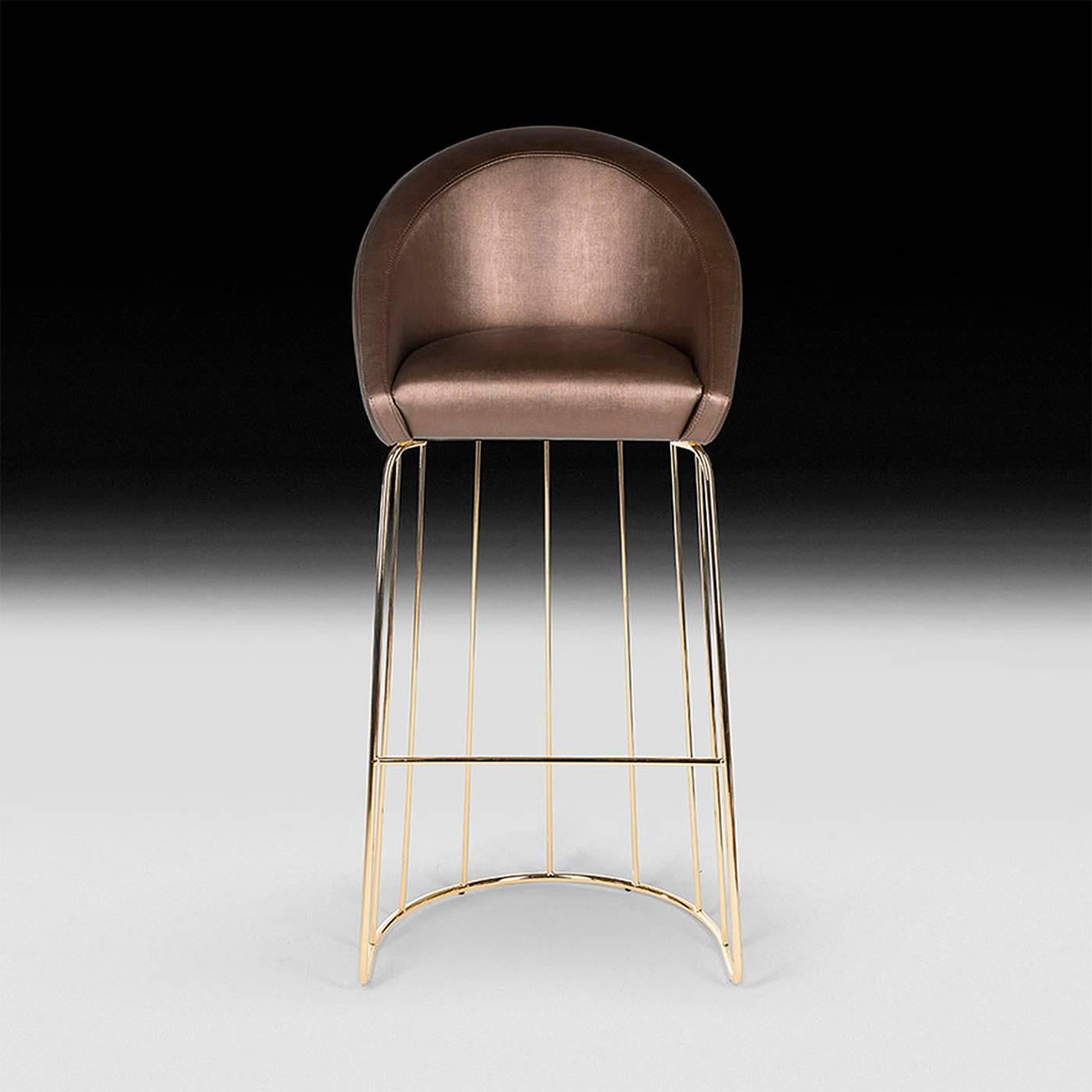 This show-stopping bar stool is a unique complement to any living room and kitchen decor. Its open brass-finished wire cage frame, with an alluring retro flair, supports a gracefully curved seat in Raina Col. Bronze (CAT. A) fabric that can be