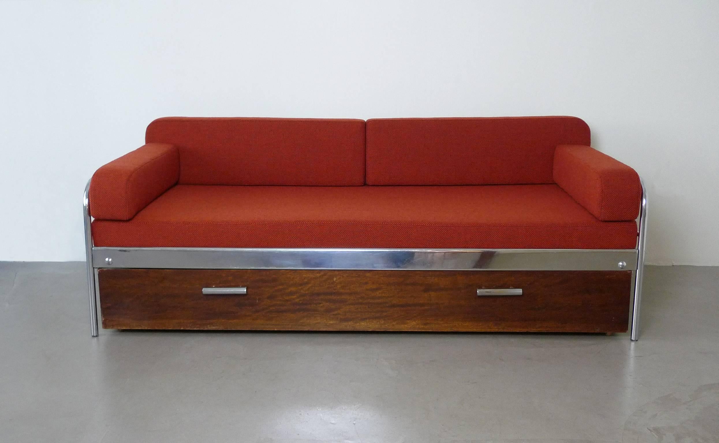 This three-seat sofa with bedding box was produced by the Czech company Mücke & Melder in the 1930s. It has a steel tube frame and a wooden bedding box with chromed holders. Upholstery and fabric are renewed.