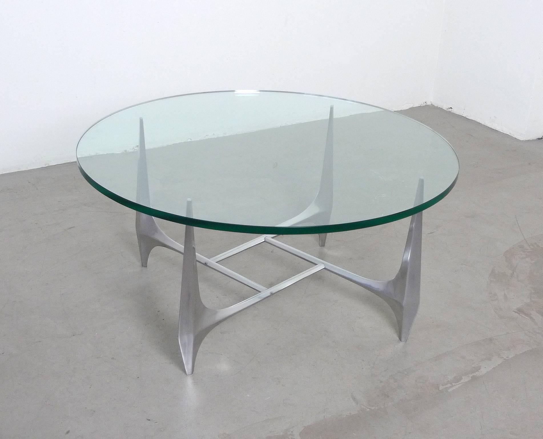 The elegant sculptural base of massive polished aluminium carries a heavy glass plate with beautiful polished edge, which is 2 cm thick and has a diameter of 99 cm. Knut Hesterberg designed this model for Ronald Schmitt in the 1960s. The table is in