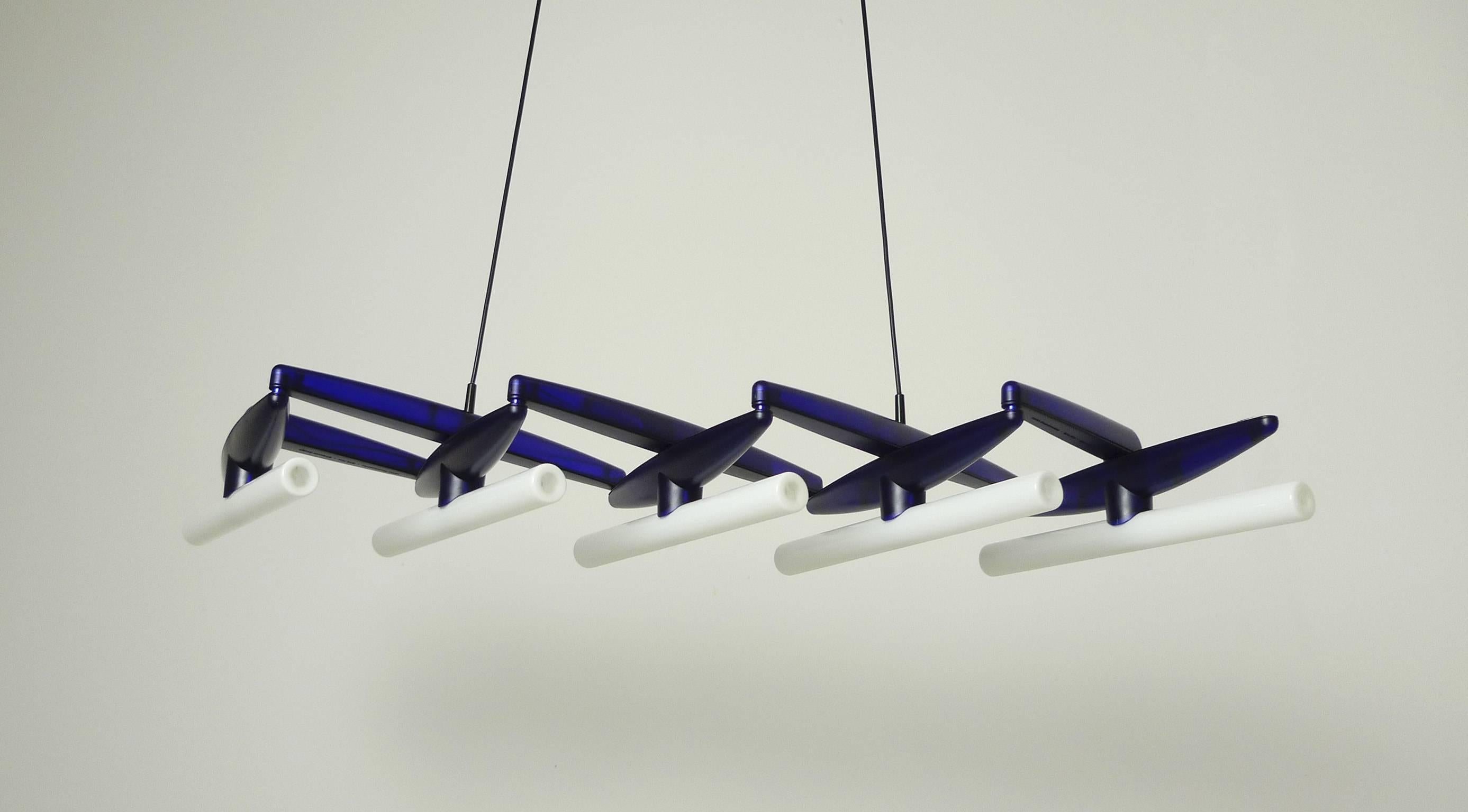 Blue extractable ceiling lamp "Take Five" from the German Design Group Ginbande. They designed it in 1993 for the producer Serien.
This lamp can be extended from the width of only 34 cm up to the maximum of 150 cm. It is made of blue
